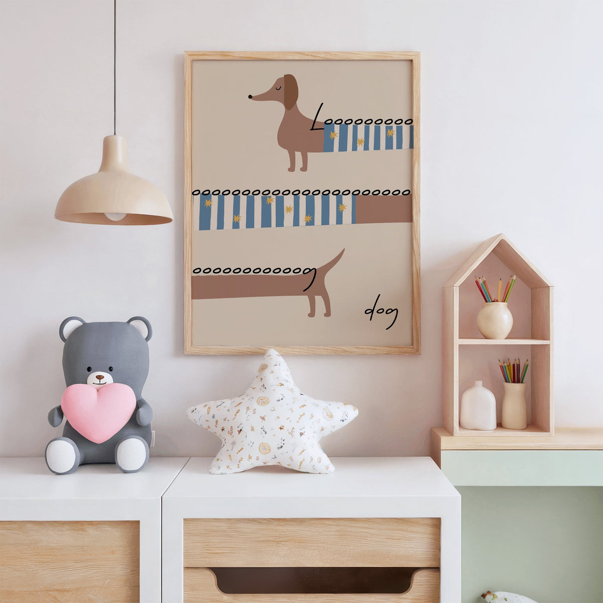 Long dog dachshund sweater nursery print in an oak frame above a white dresser with a star pillow and house shelf