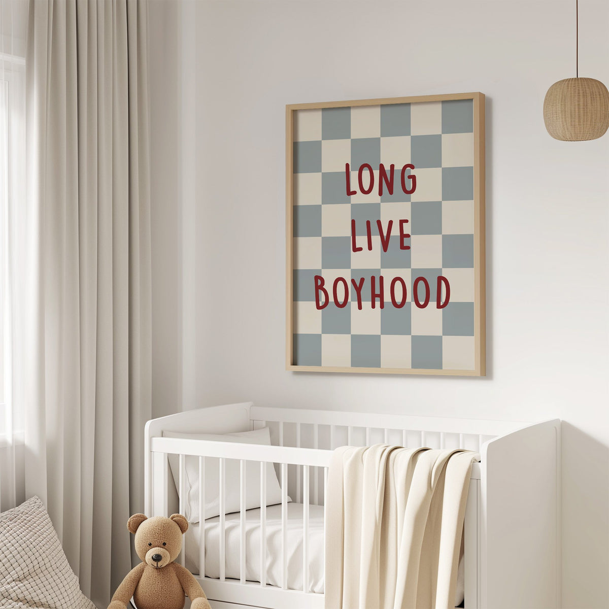 Long live boyhood checker nursery print in an oak frame above a white crib with a teddy bear