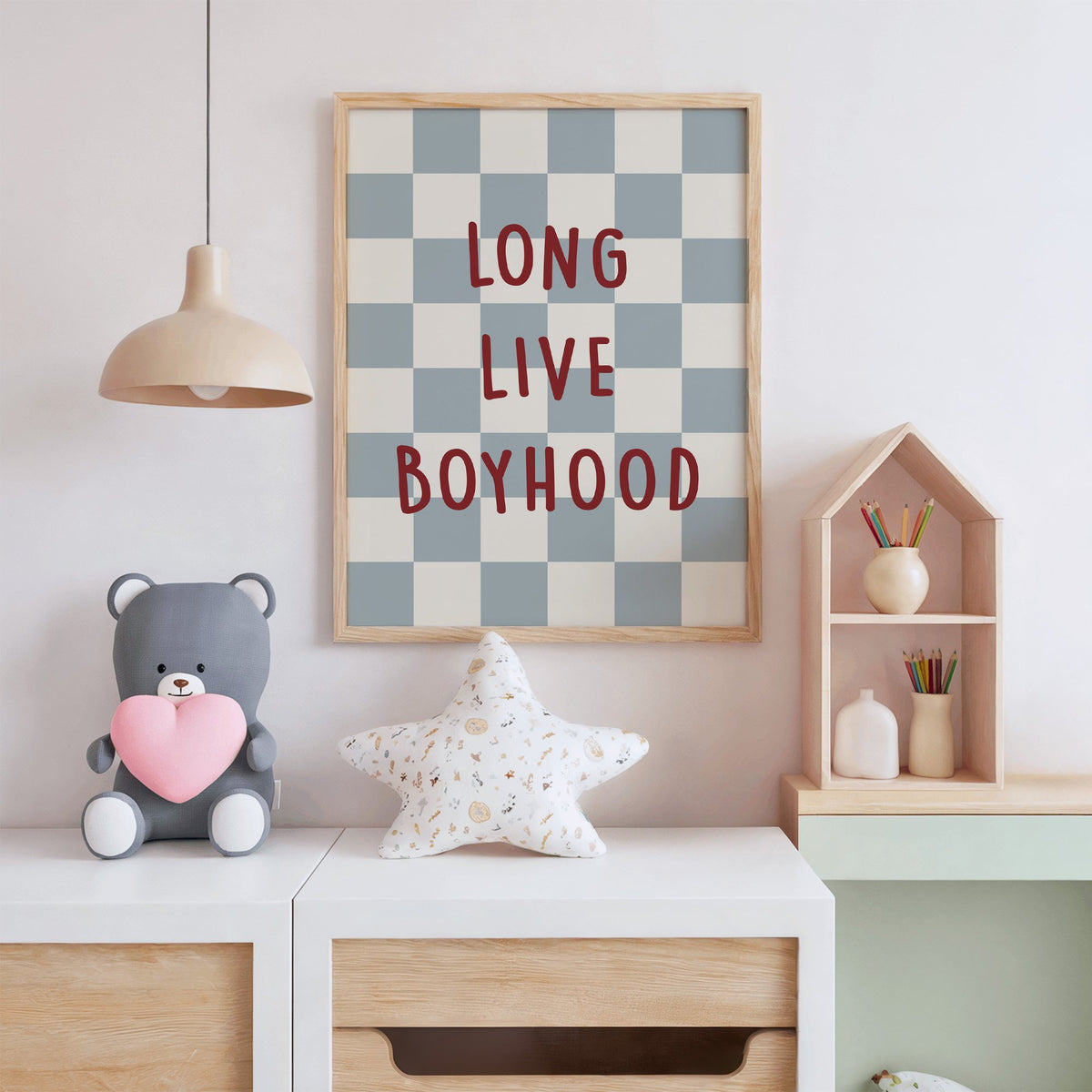 Long live boyhood checker nursery print in an oak frame above a white dresser with a star pillow and house shelf