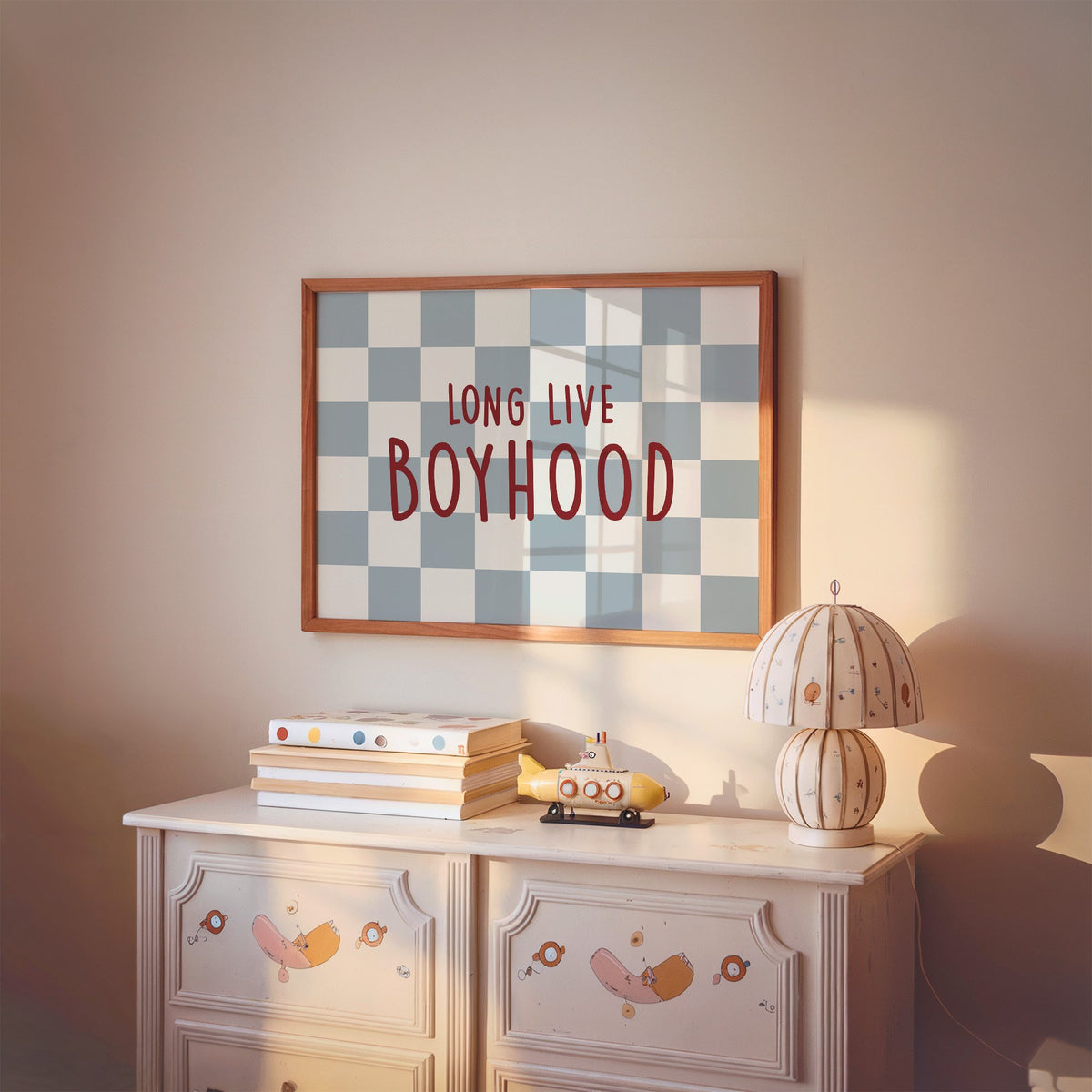 Landscape long live boyhood checker nursery print in a cherry wood frame above a painted dresser and lamp