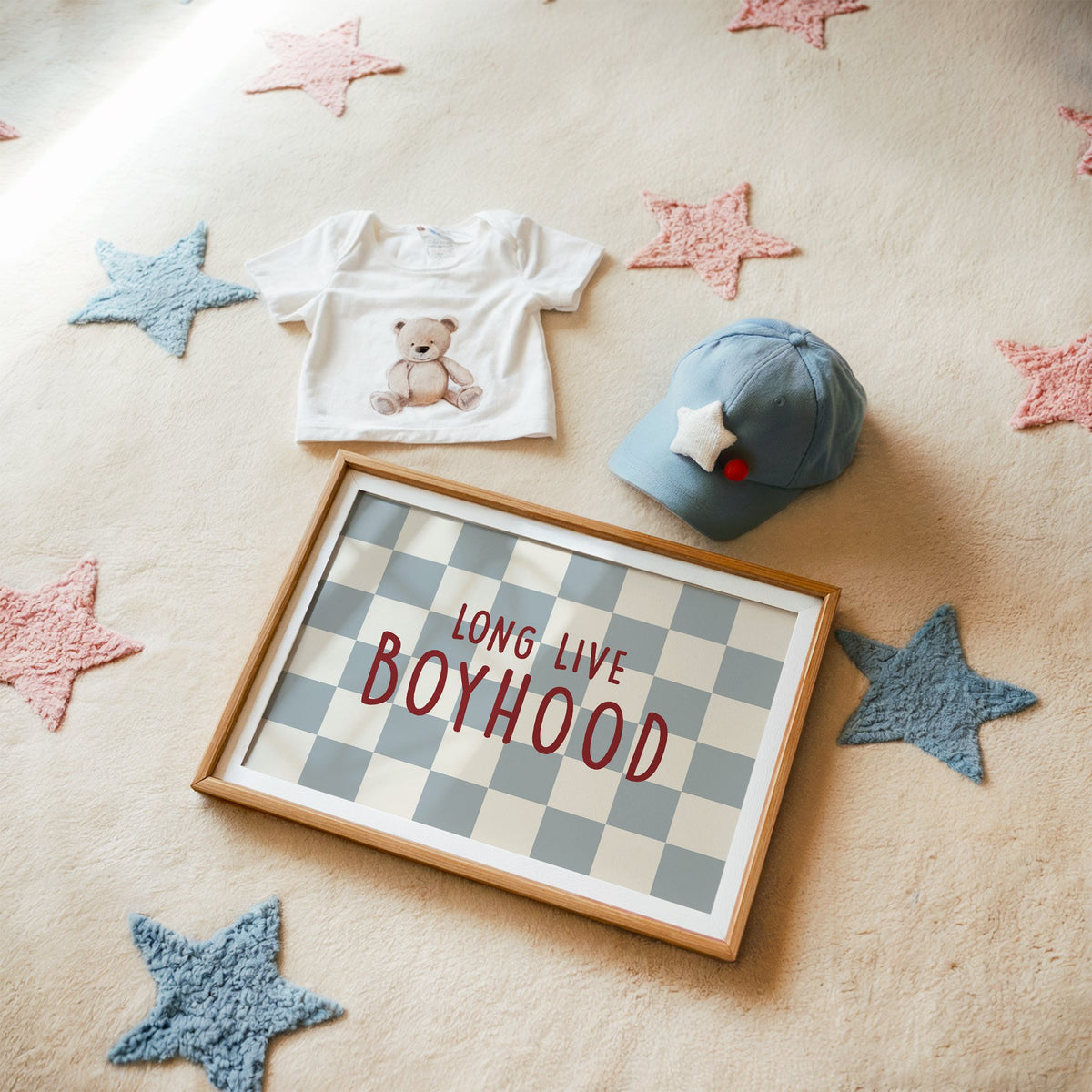 Landscape long live boyhood checker nursery print in a matted oak frame on a star rug with a baby tee