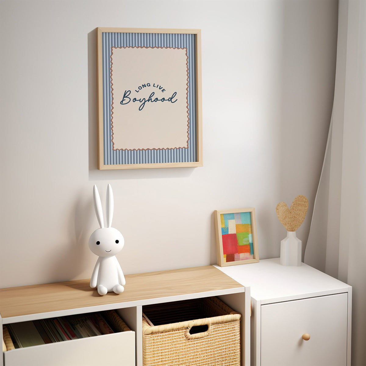 Long live boyhood nursery print in an oak frame above a kids cubby shelf with a woven basket and bunny lamp