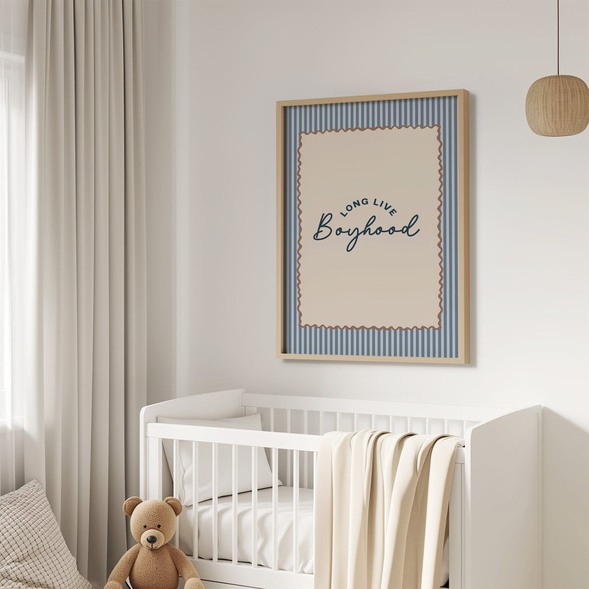 Long live boyhood nursery print in an oak frame above a white crib with a teddy bear