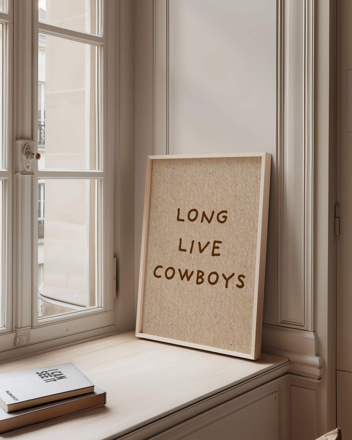 Long Live Cowboys kraft print in a pale wood frame on a sunlit window ledge