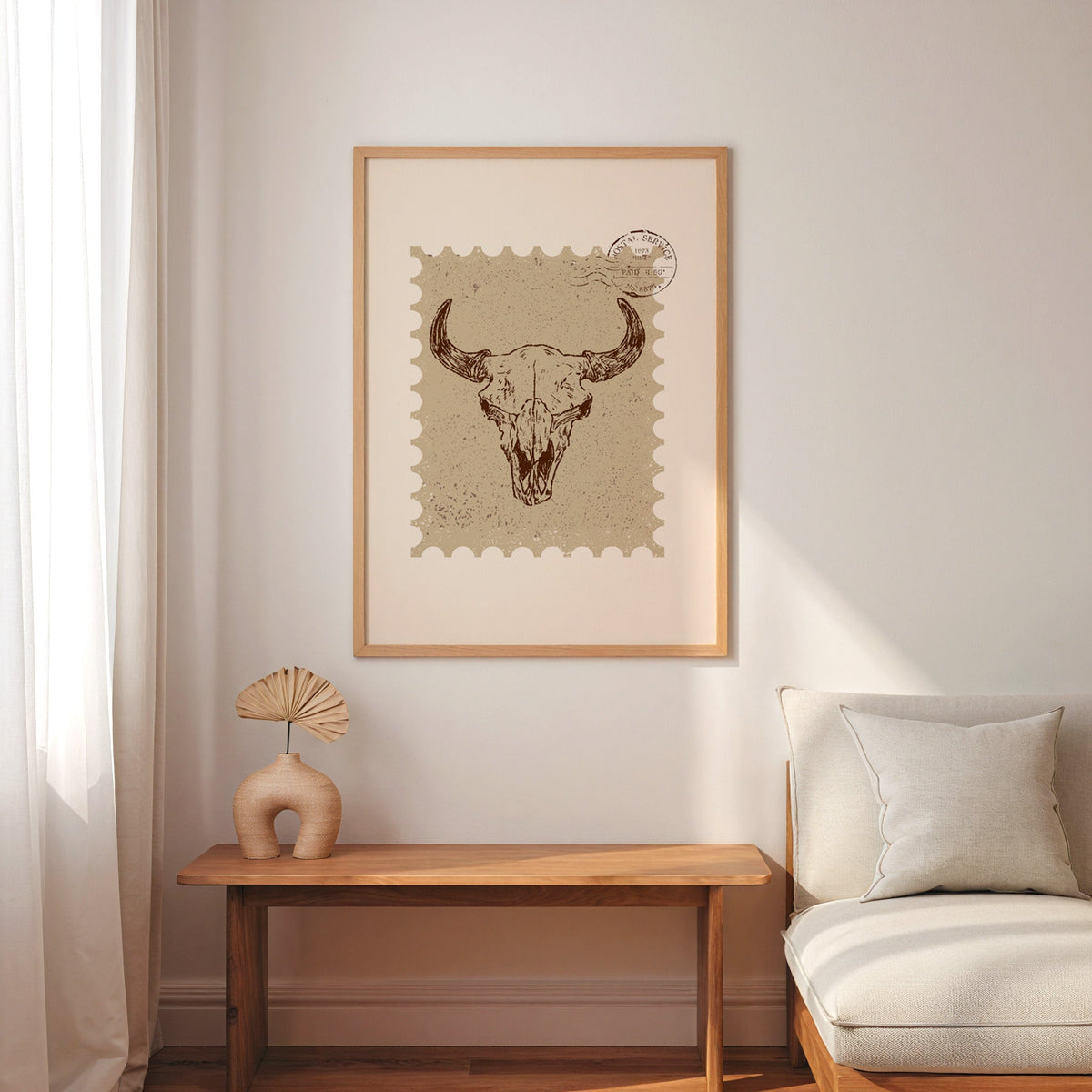 Longhorn skull stamp print in an oak frame above a console with an arch vase