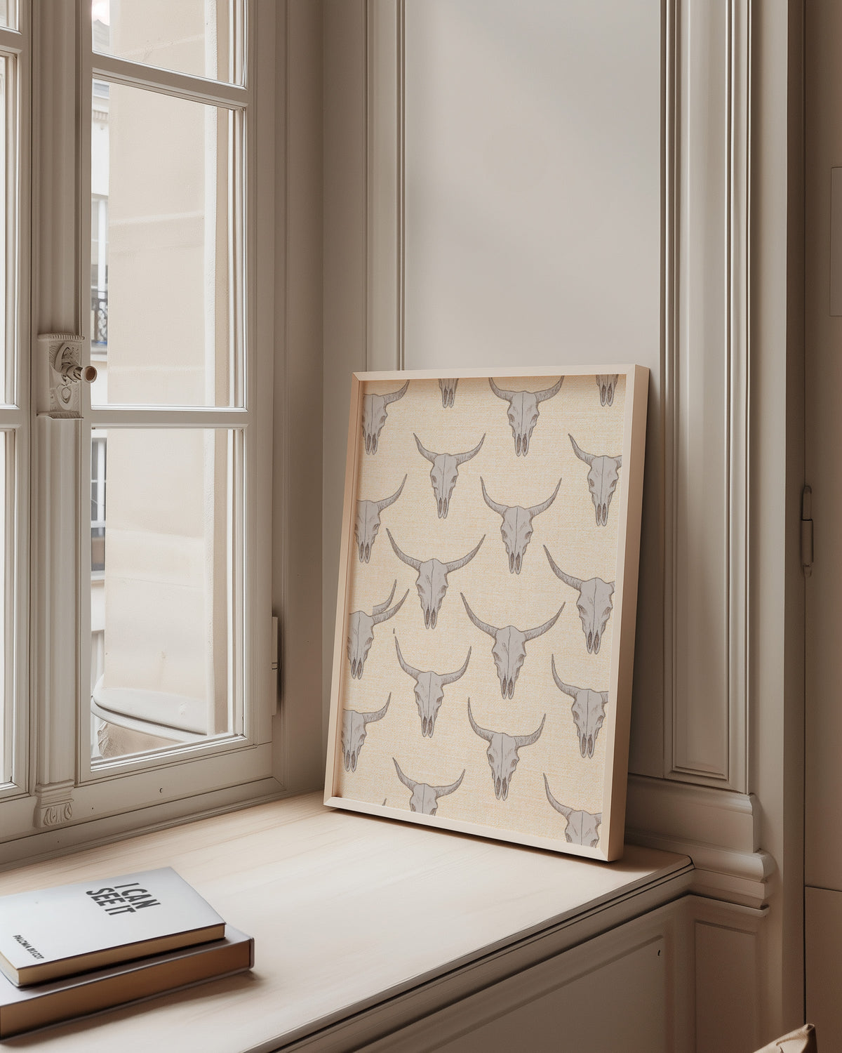 Longhorn skull cream pattern print in a pale wood frame on a sunlit window ledge