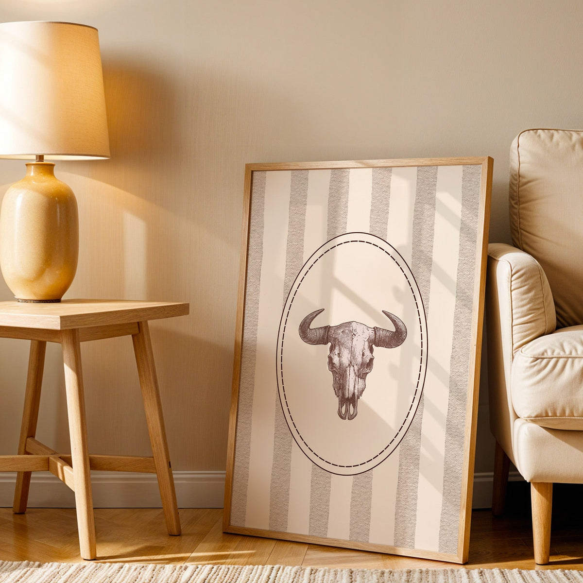 Longhorn skull cameo print in an oak frame beside an amber ceramic lamp