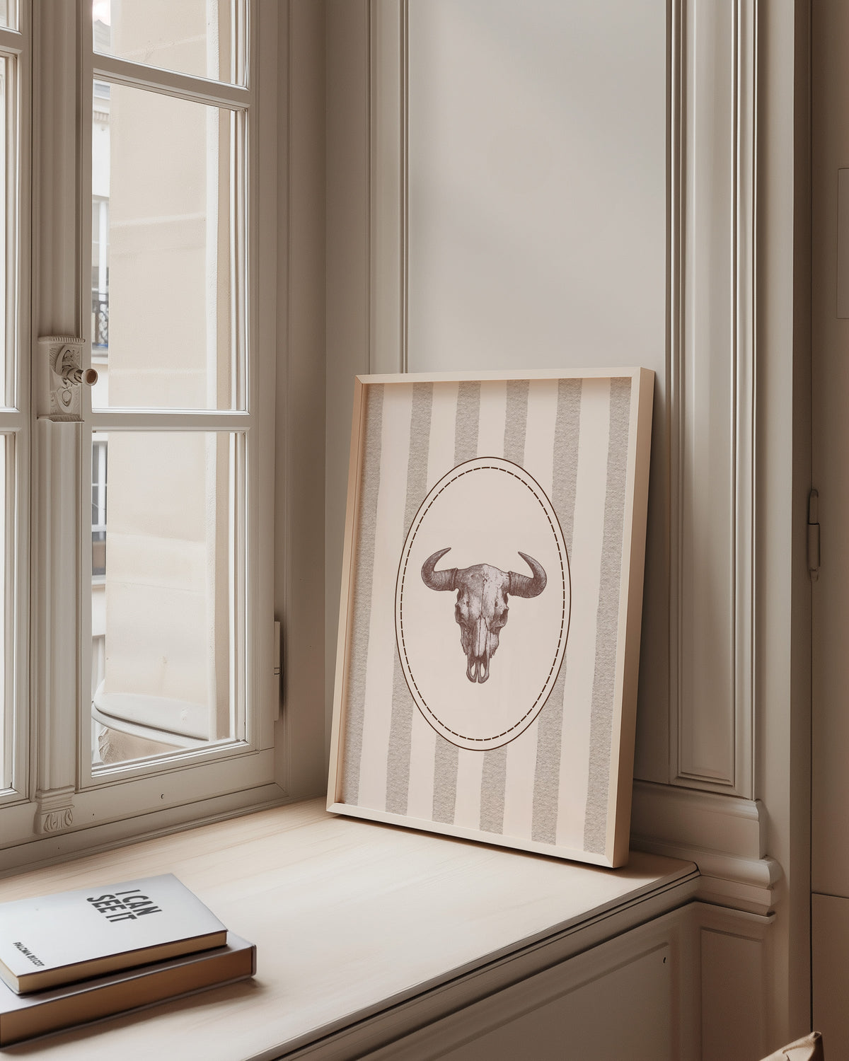 Longhorn skull cameo print in a pale wood frame on a sunlit window ledge
