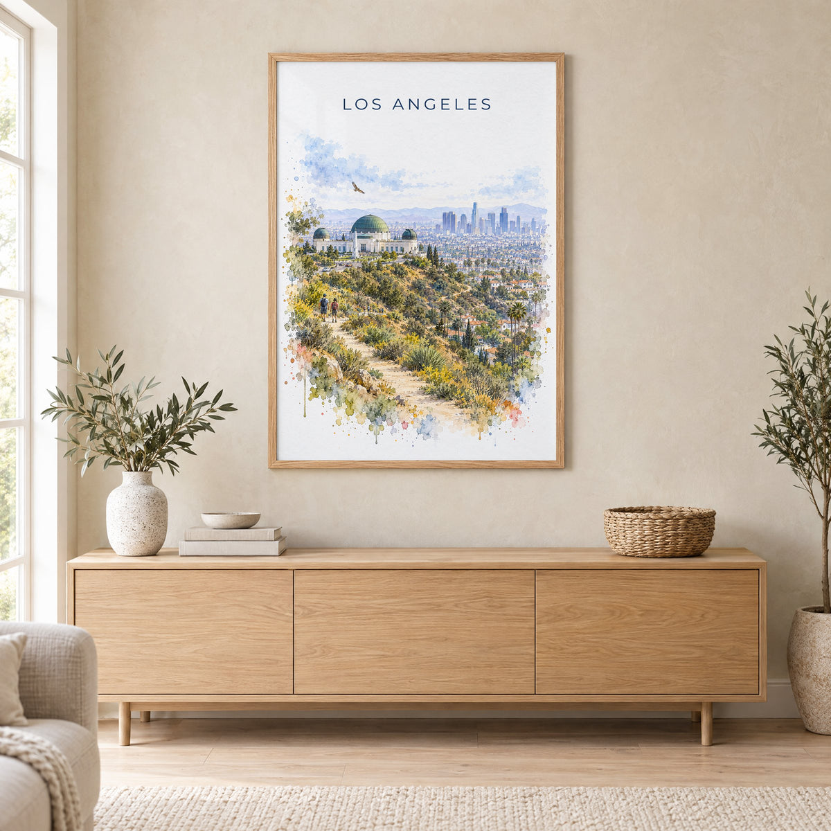 Los Angeles watercolor print in an oak frame above a light wood sideboard in a Scandinavian living room