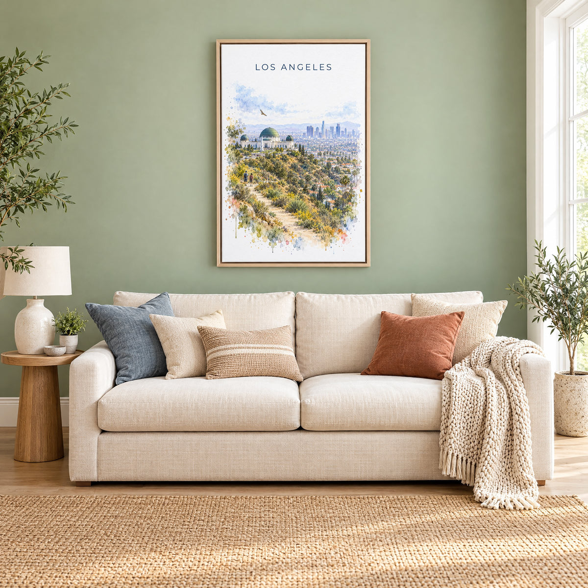 Los Angeles watercolor print as a natural floater canvas above a cream linen sofa on a sage green wall