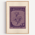 Louisiana state flower stamp print in aubergine on dusty mauve, light oak frame on a plain white wall
