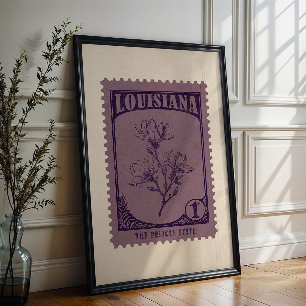 Louisiana state flower print in a black frame leaning against a white panelled wall beside olive branches