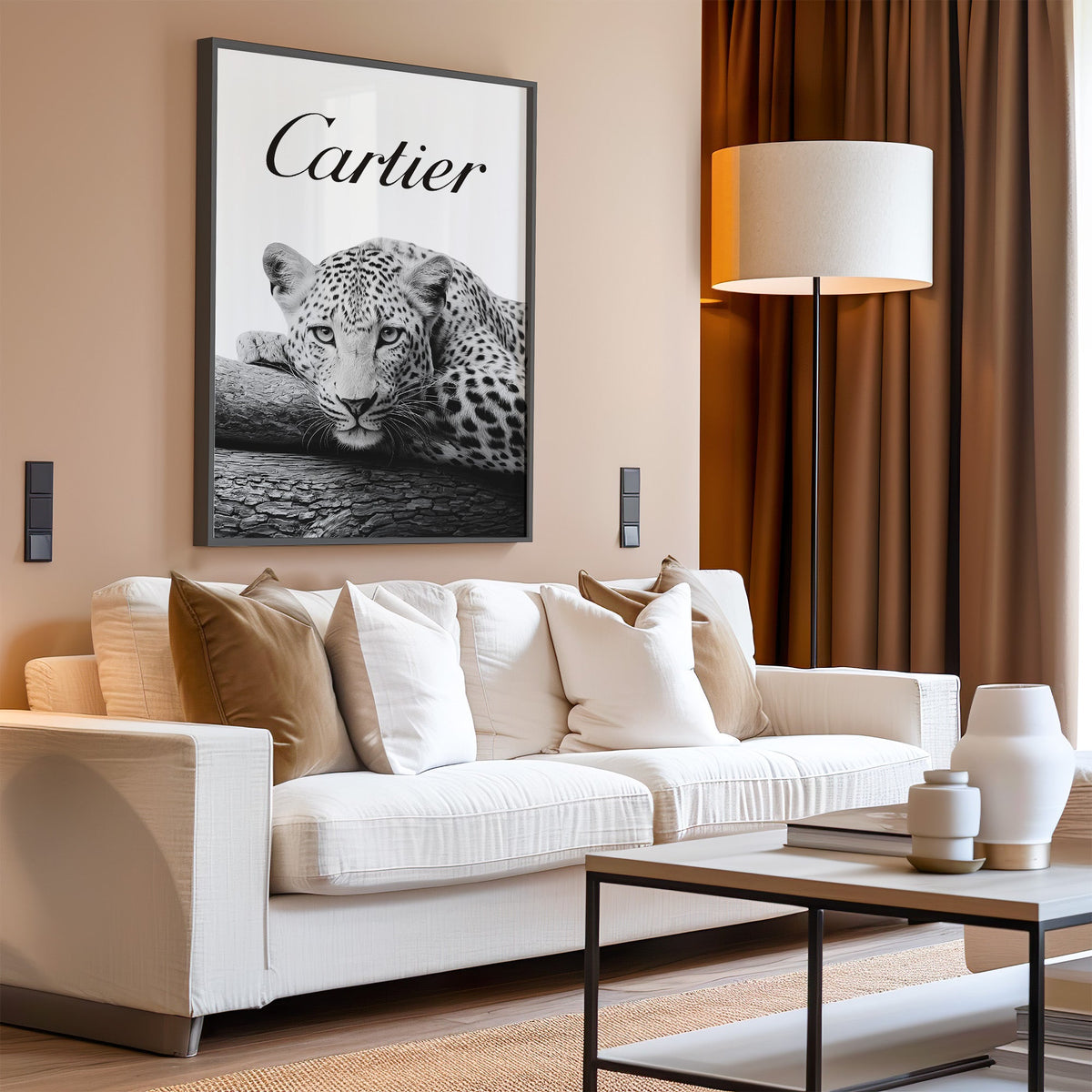 Leopard resting chin on cracked log with script wordmark in a black frame above a cream sofa on a blush living room wall