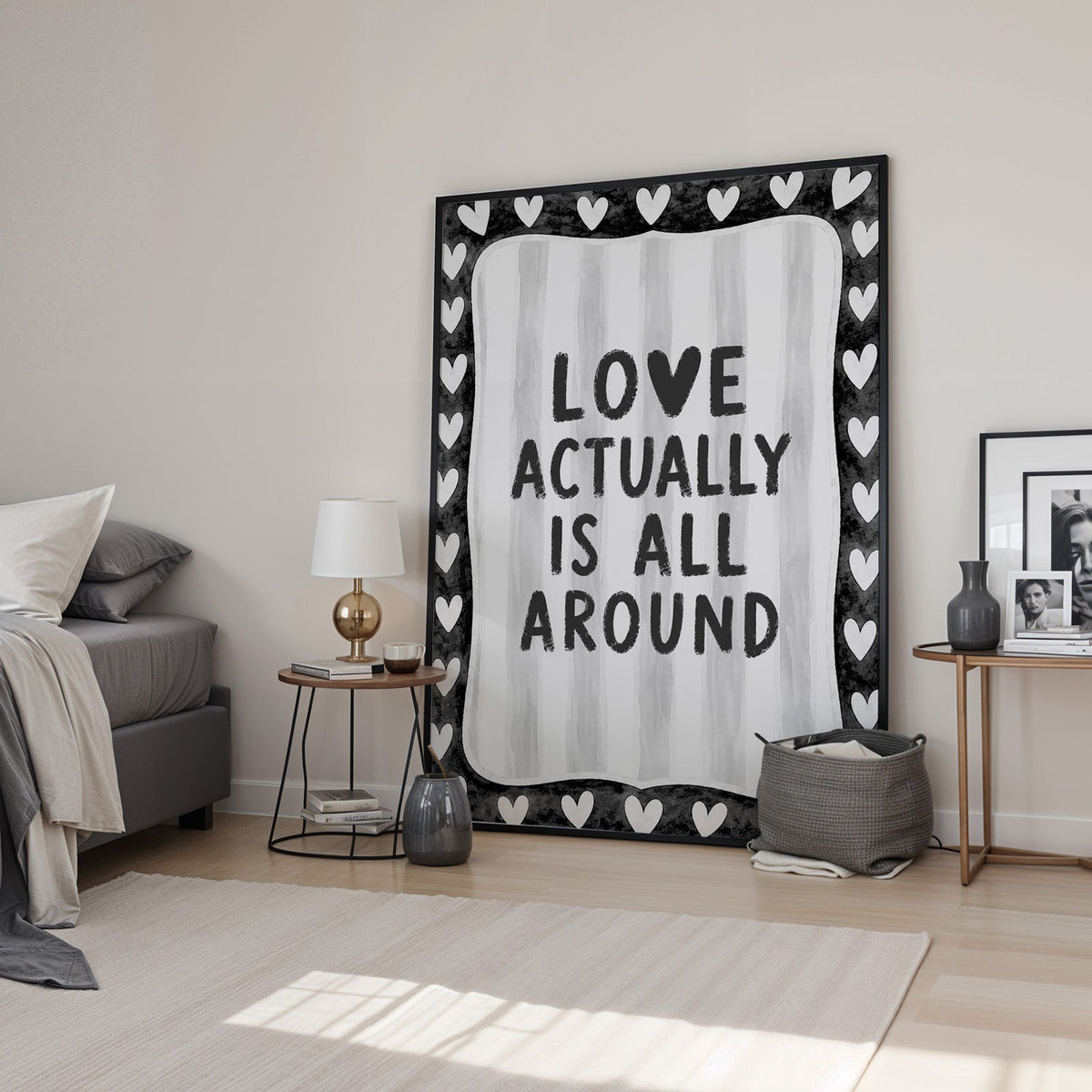 Love actually is all around hearts border print in a black frame leaning in a bedroom beside a gold lamp