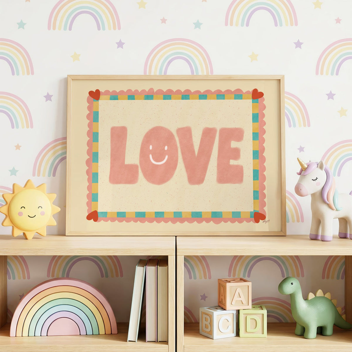 Love smiley face checkered border nursery print in an oak frame on a toy shelf against rainbow wallpaper