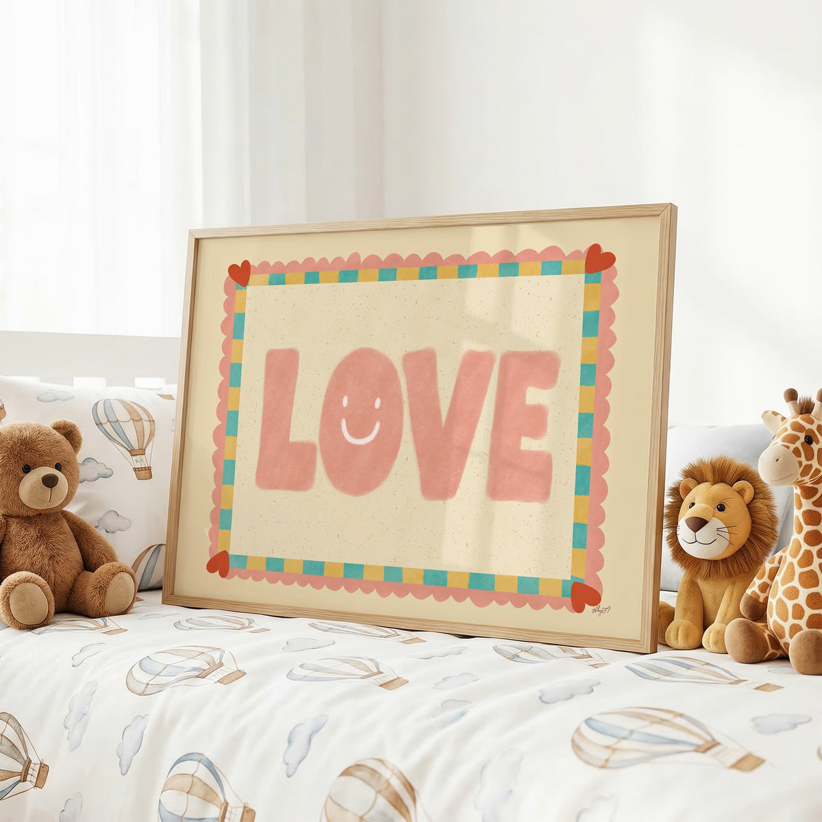 Love smiley face checkered border nursery print in an oak frame on a kids bed with hot air balloon bedding