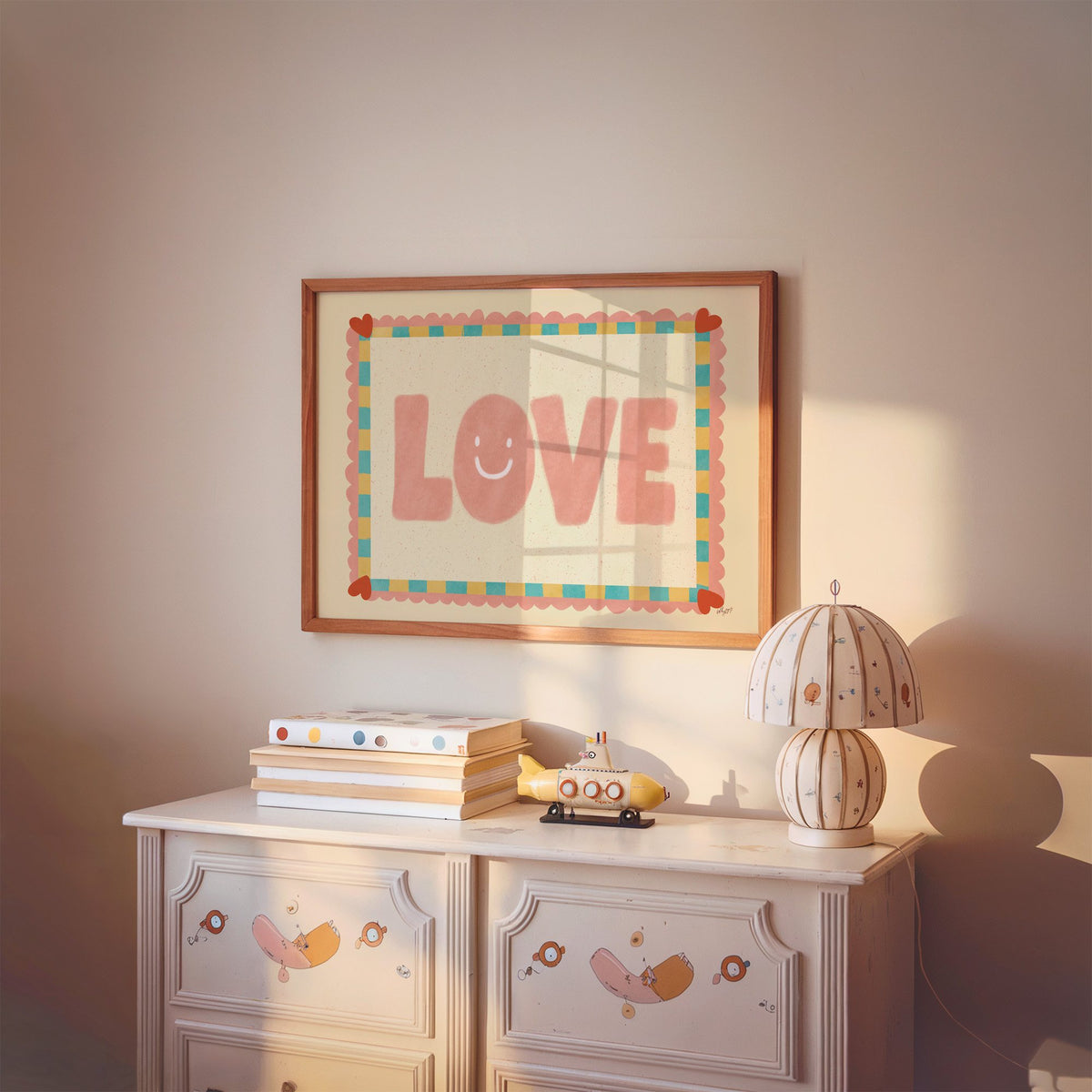 Love smiley face checkered border nursery print in a cherry wood frame above a painted dresser and lamp