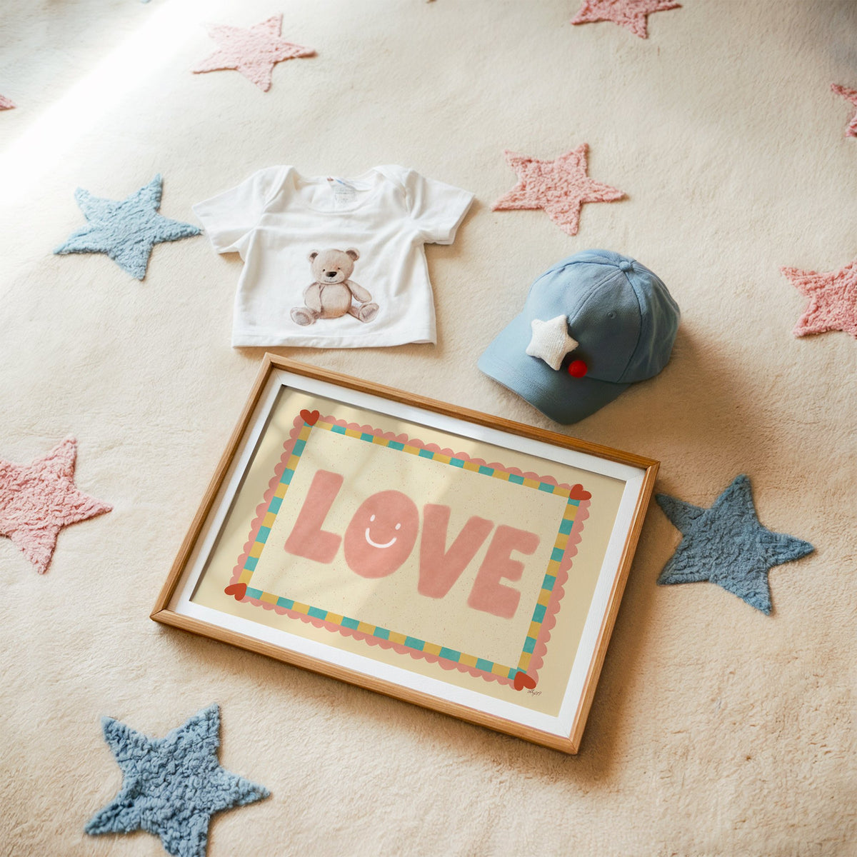 Love smiley face checkered border nursery print in a matted oak frame on a star rug with a baby tee