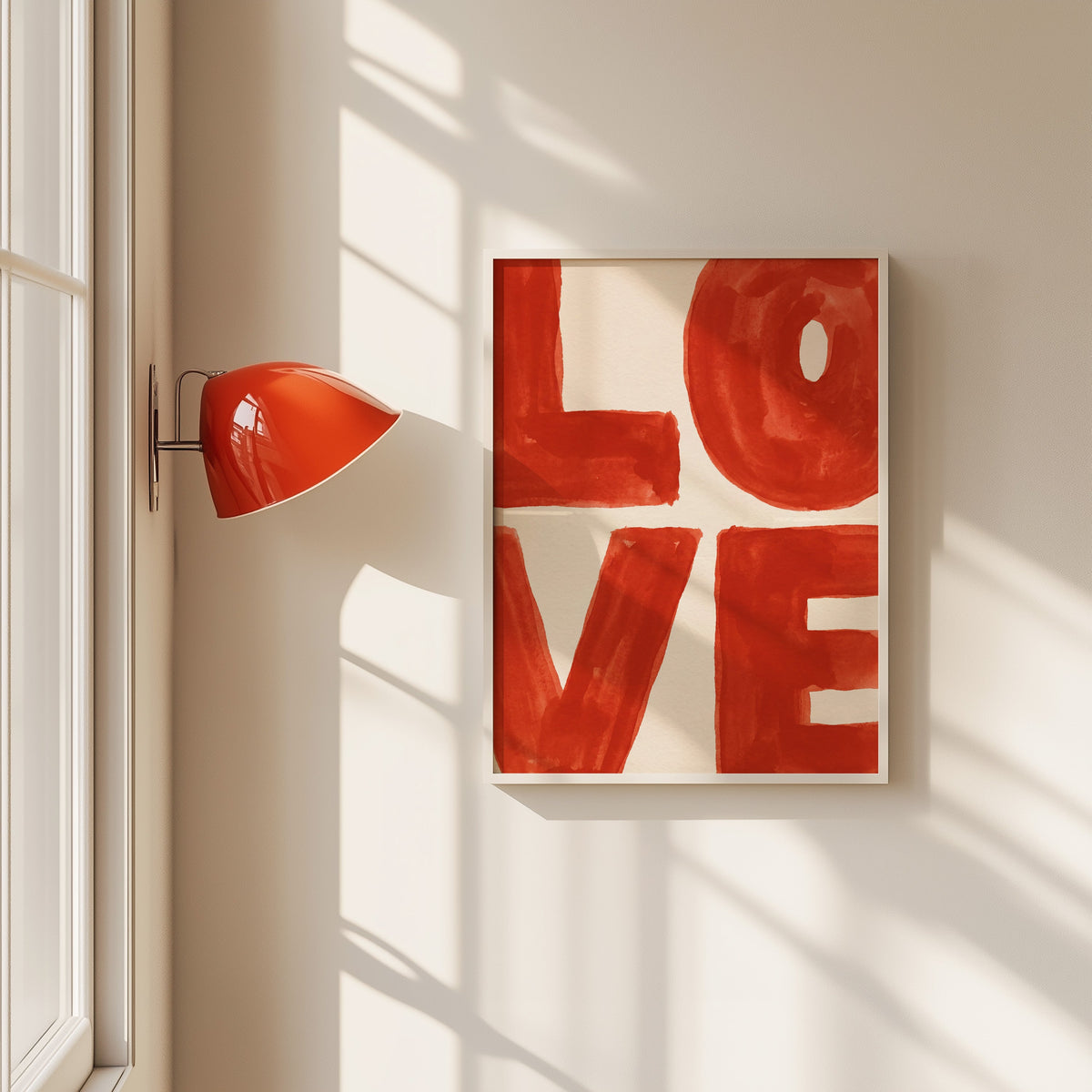 LOVE watercolor letters print in a white frame beside a red wall sconce
