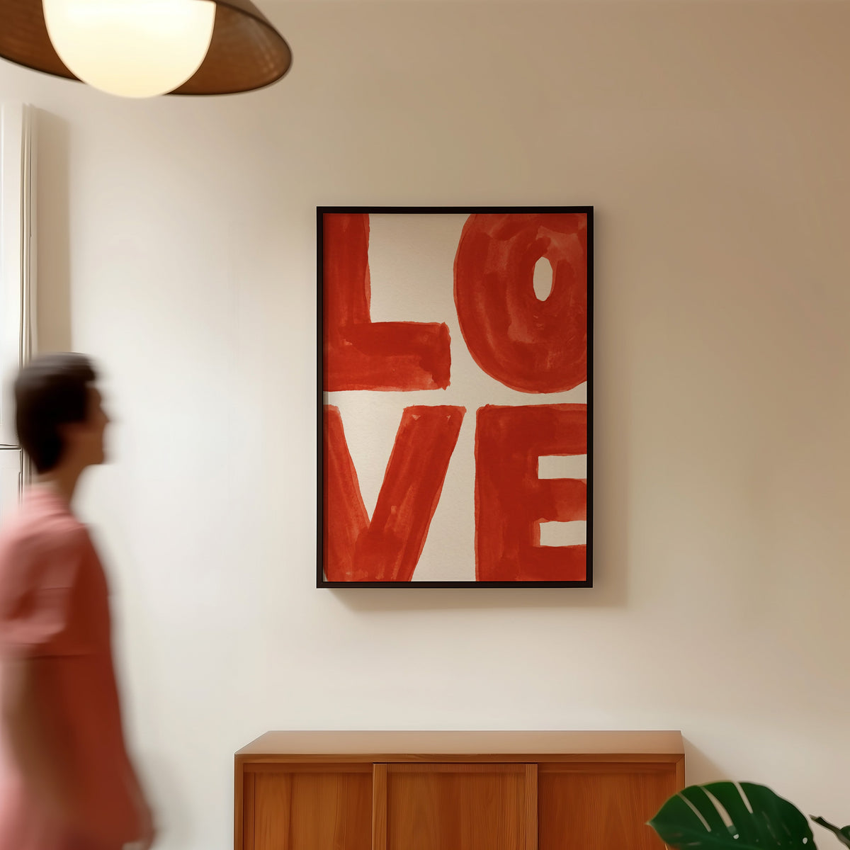 LOVE typography print in a black frame in a hallway under a rattan pendant
