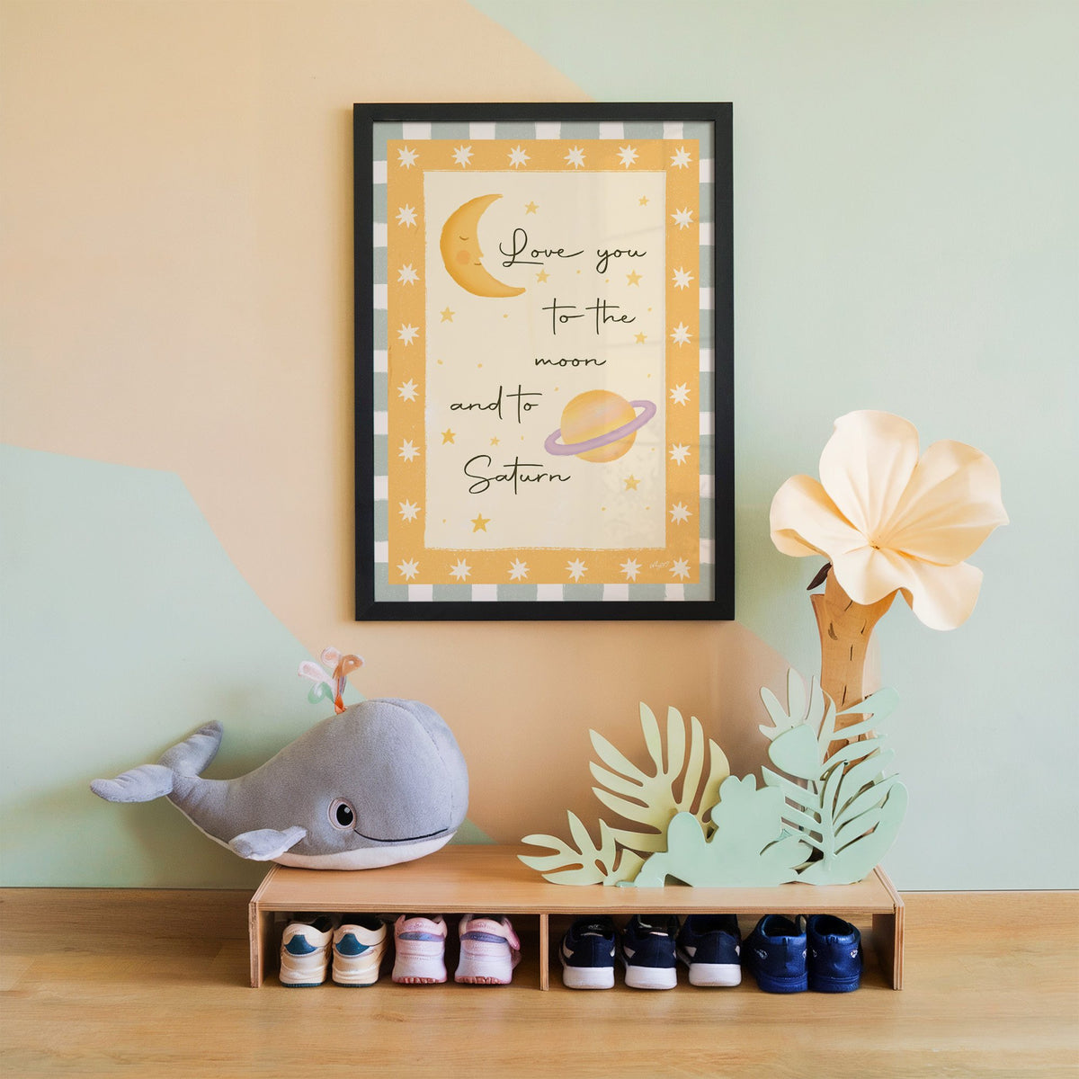 Love you moon and saturn nursery print in a black frame on a mint and peach wall above a whale plush