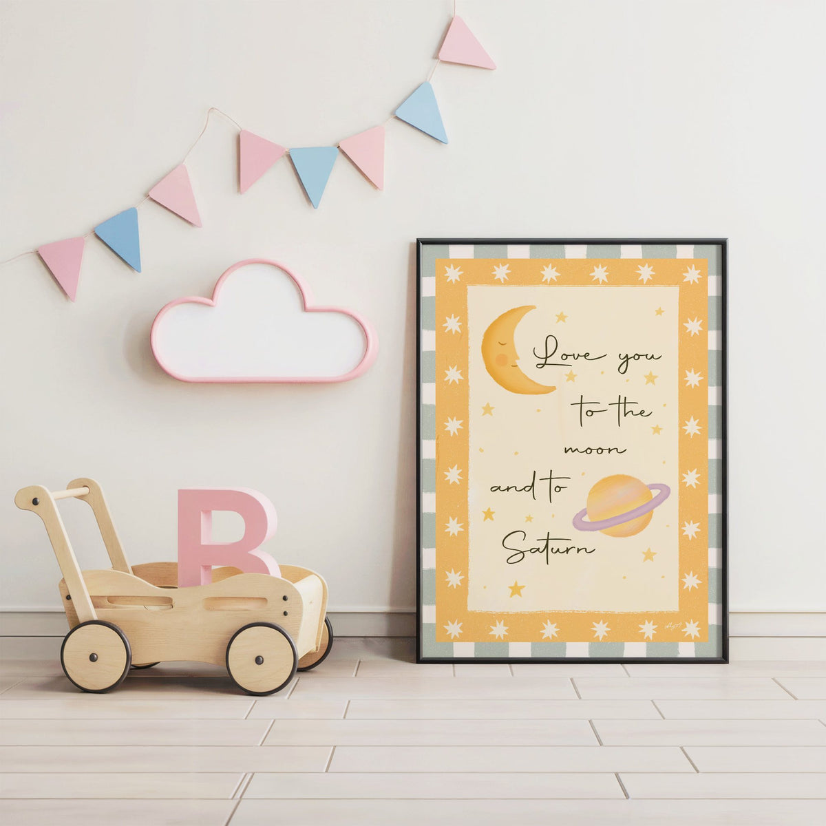 Love you moon and saturn nursery print in a black frame under pastel bunting by a wooden baby walker