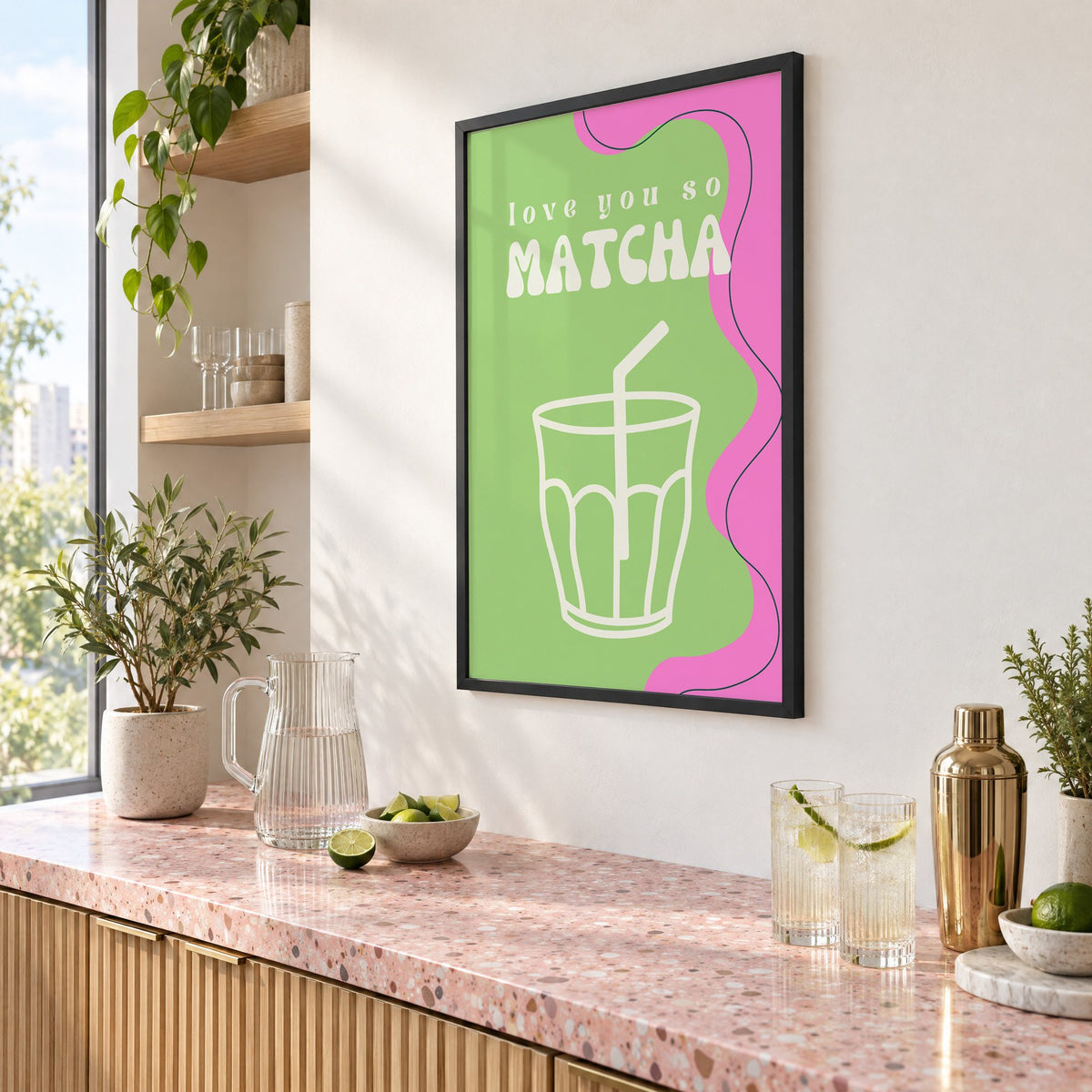 Love you so MATCHA outline glass print in a black frame above a pink terrazzo cocktail counter with limes, seen at an angle