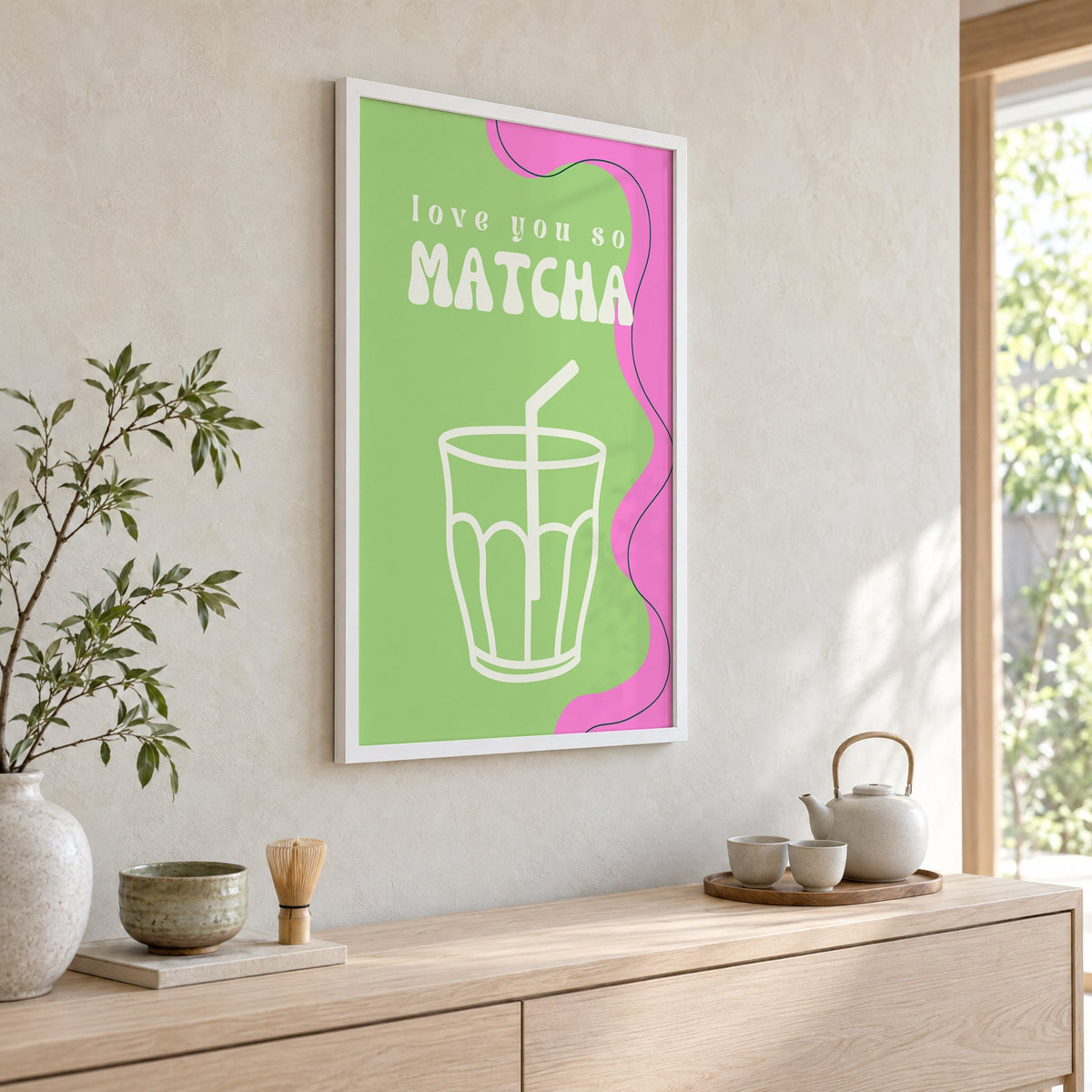 Love you so MATCHA outline glass print in a white frame above a pale wood console with a matcha tea set