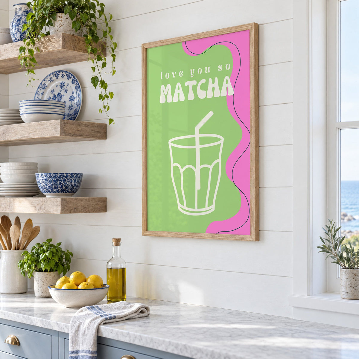 Love you so MATCHA outline glass print in an oak frame in a white coastal kitchen beside blue and white plates