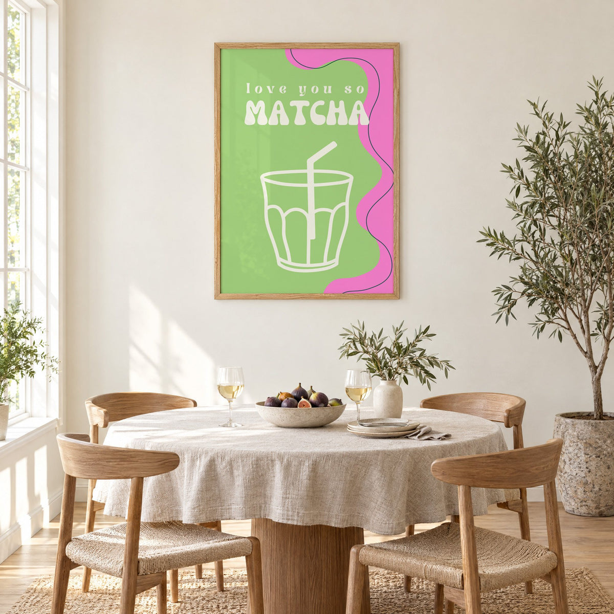 Love you so MATCHA outline glass print in an oak frame above a round linen-covered dining table with figs and wine