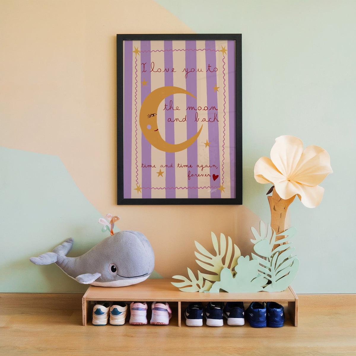 Love you to the moon lilac nursery print in a black frame on a mint and peach wall above a whale plush