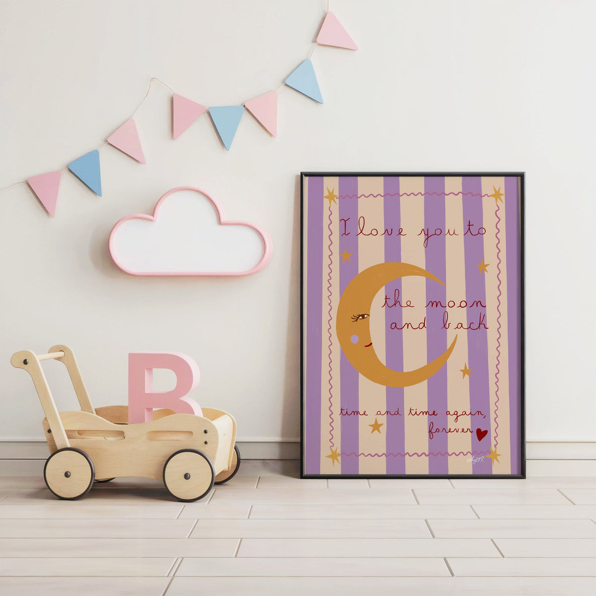 Love you to the moon lilac nursery print in a black frame under pastel bunting by a wooden baby walker