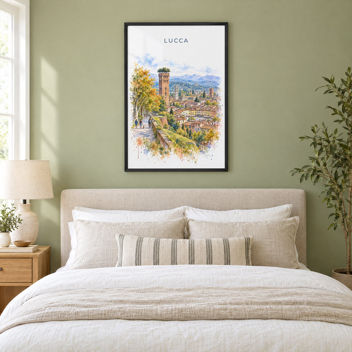 Lucca watercolor print in a black frame above an upholstered headboard in a sage green bedroom