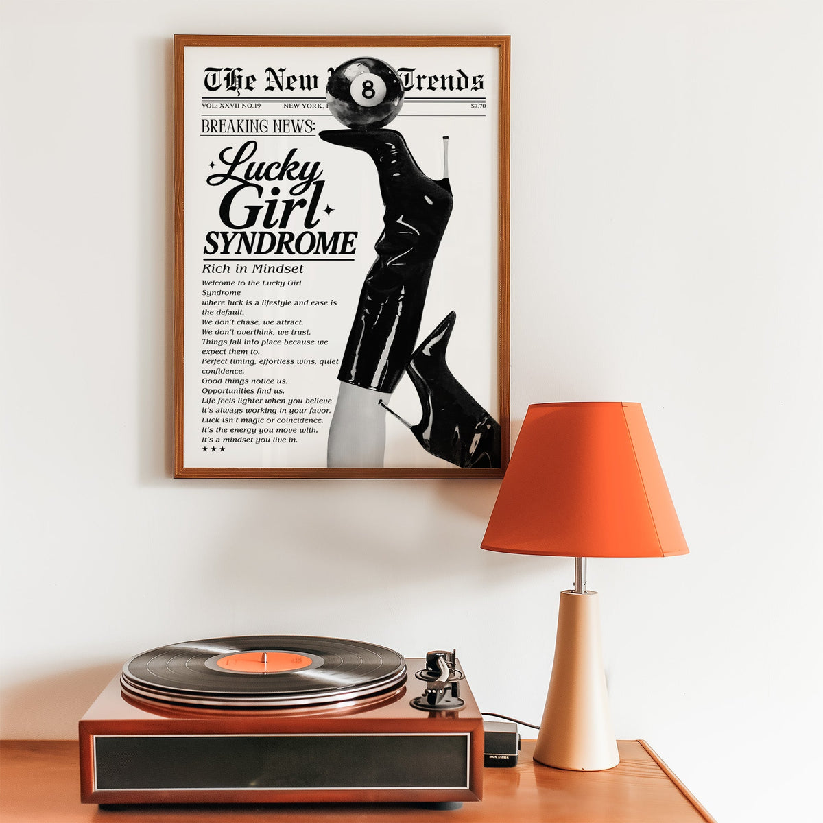 Lucky Girl Syndrome mock newspaper with boots print in a walnut frame above a record player and orange lamp