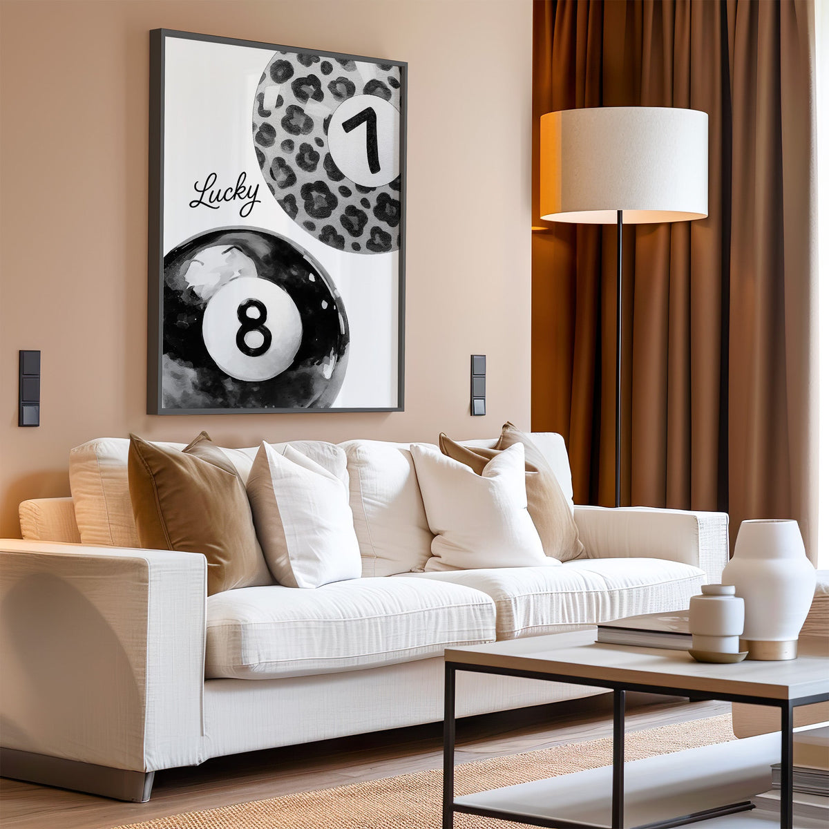 Leopard seven ball and black eight ball watercolor print in a black frame above a cream sofa on a blush living room wall
