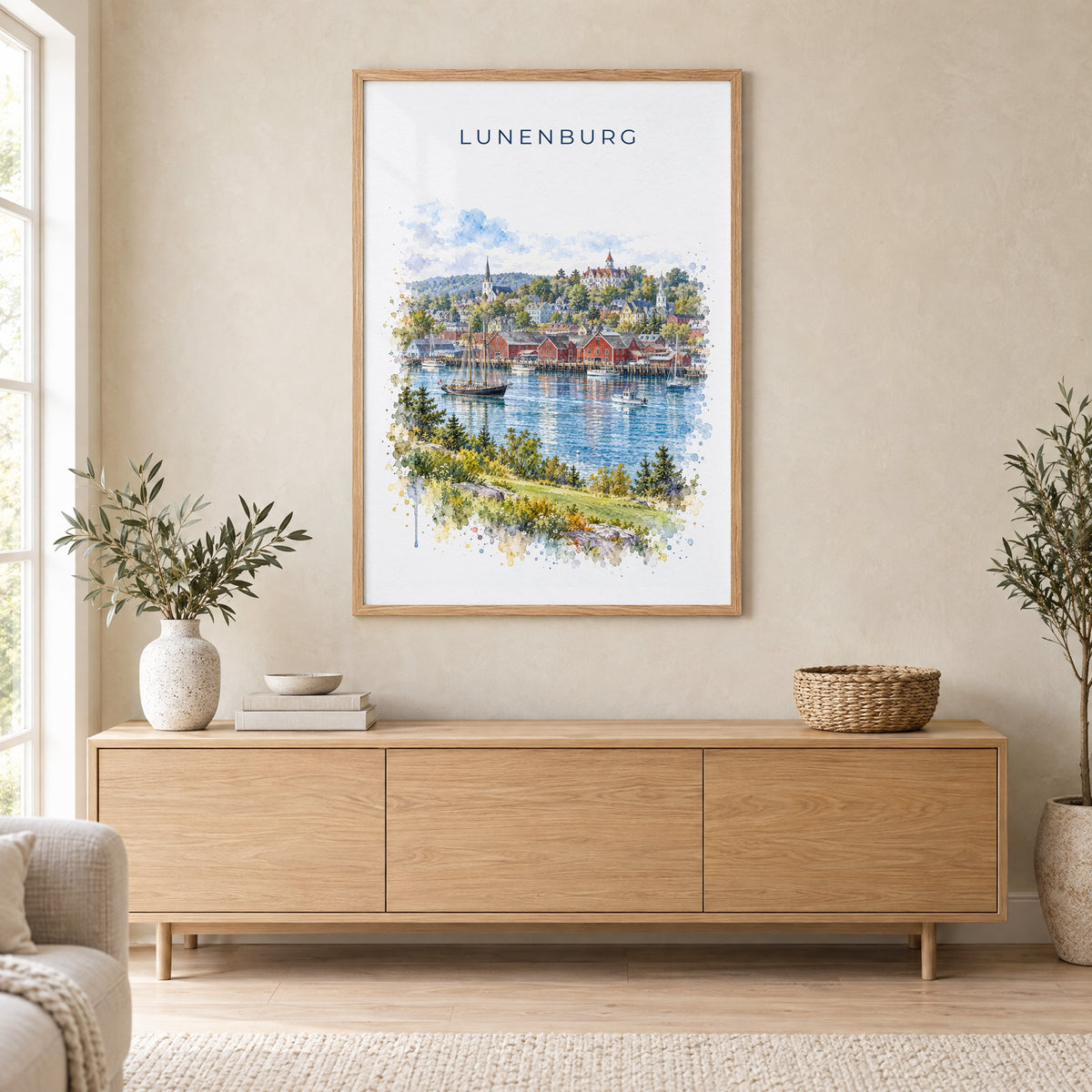 Lunenburg watercolor print in an oak frame above a light wood sideboard in a Scandinavian living room