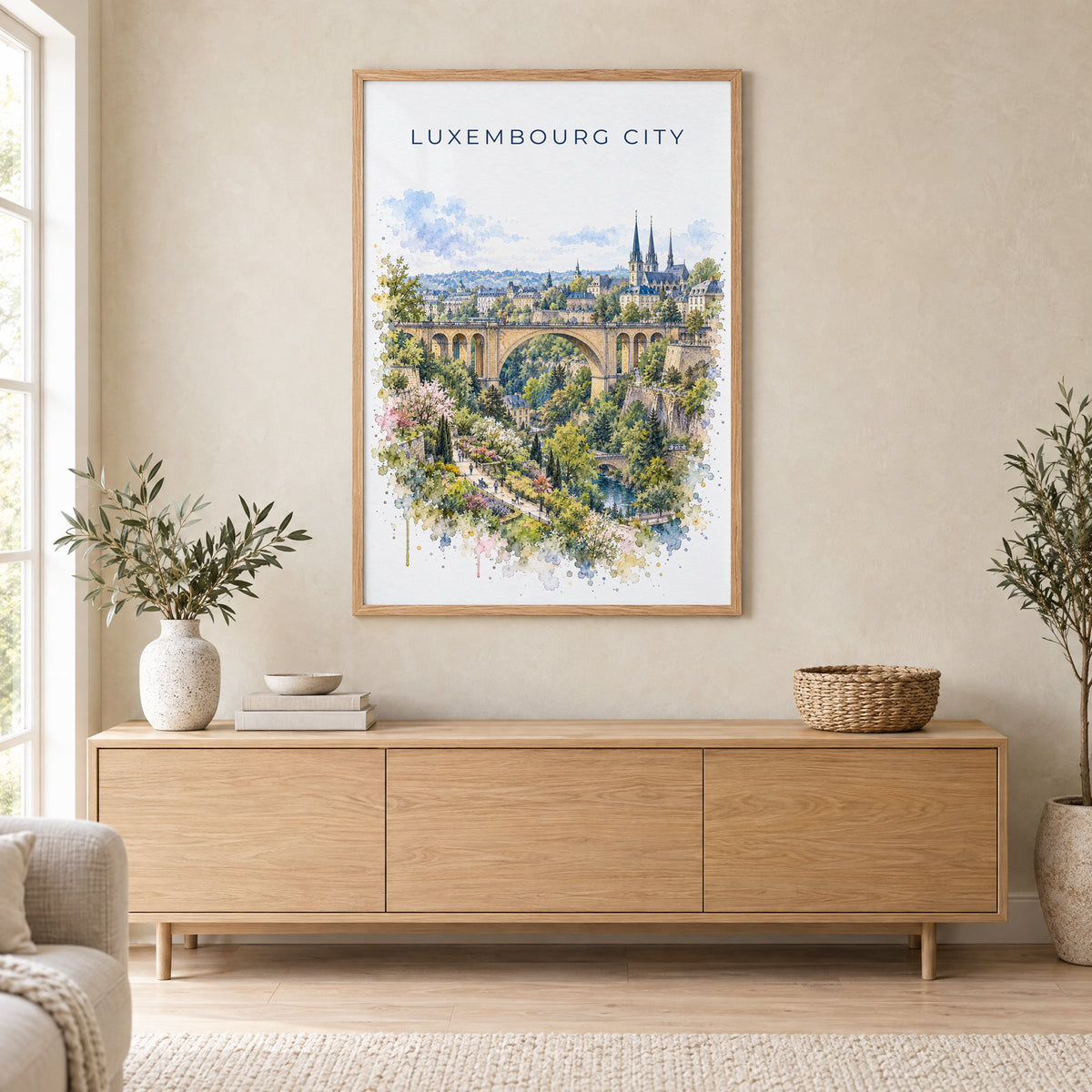 Luxembourg City watercolor print in an oak frame above a light wood sideboard in a Scandinavian living room