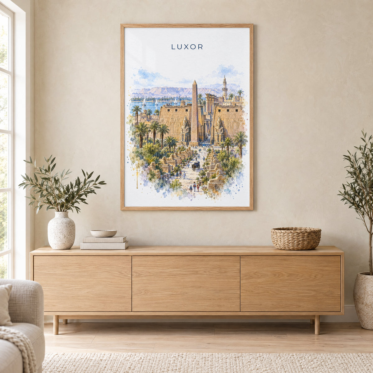 Luxor watercolor print in an oak frame above a light wood sideboard in a Scandinavian living room