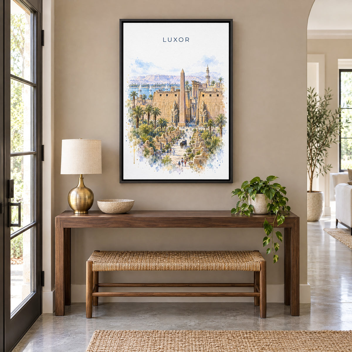 Luxor watercolor print as a black floater canvas above a walnut console and woven bench in an entryway