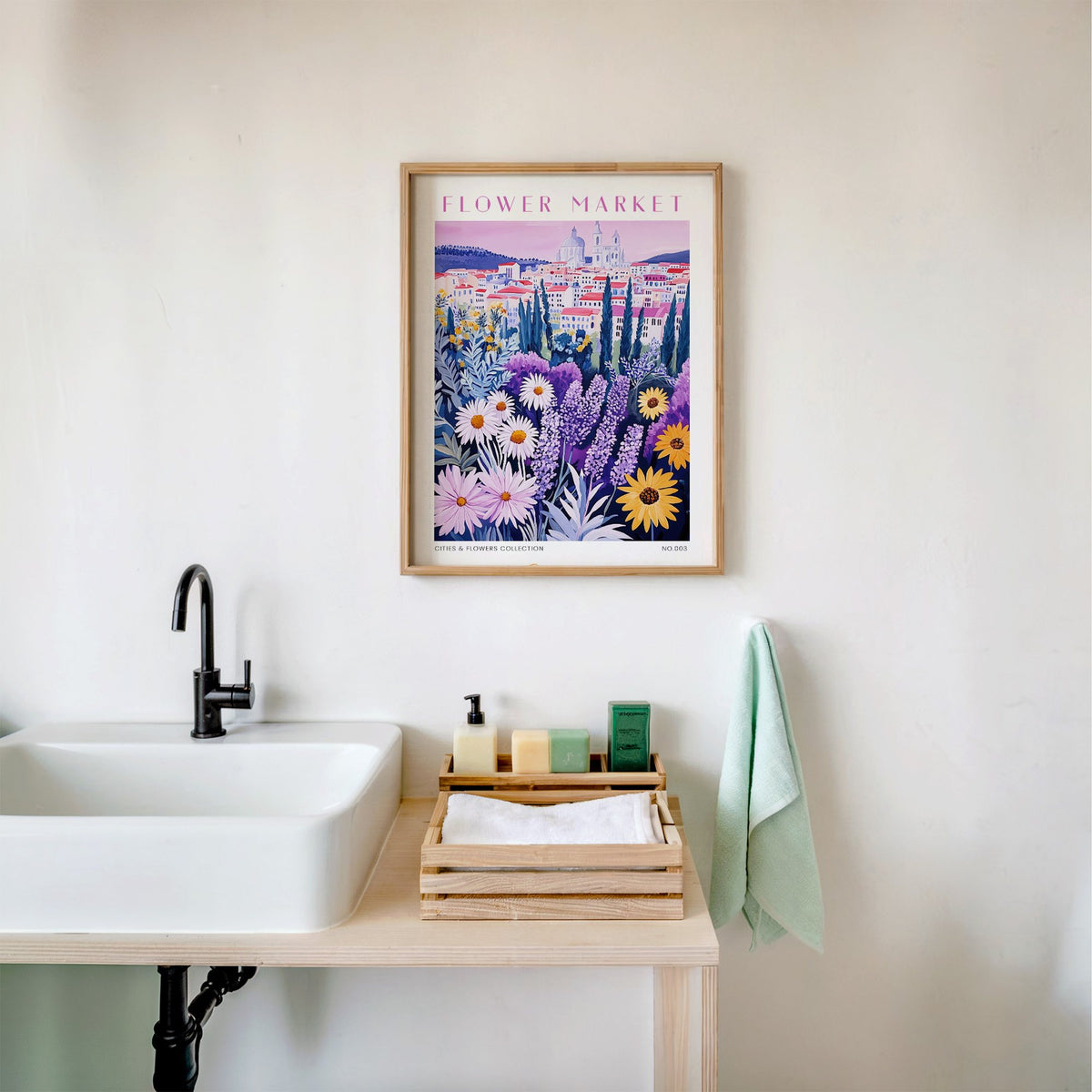 Lyon flower market print in an oak frame above a white bathroom sink with folded towels
