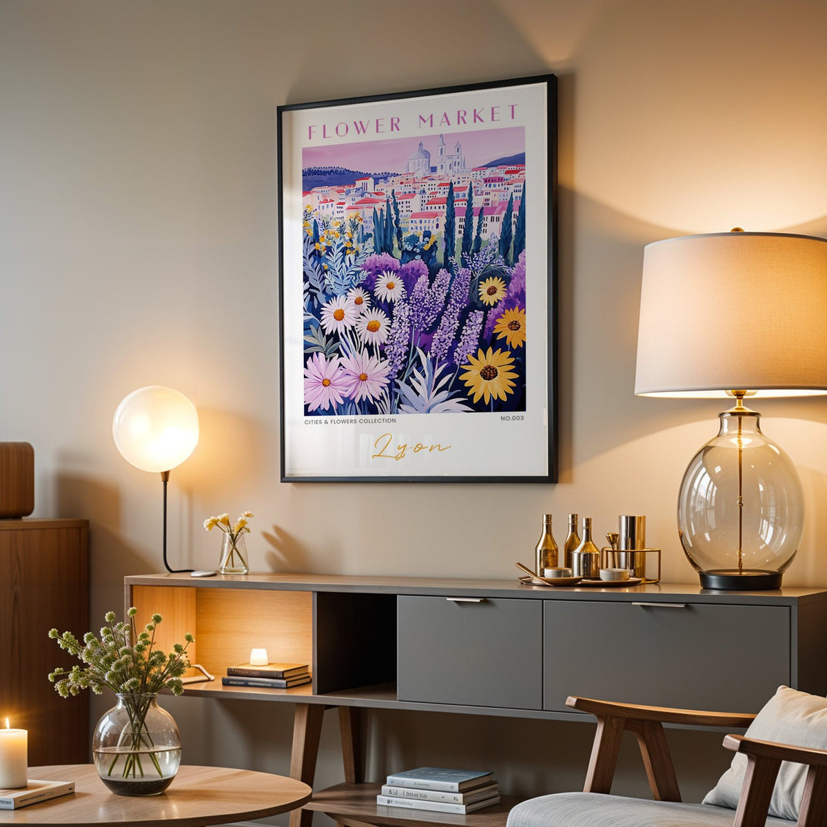 Lyon flower market print in a black frame above a grey media console with a glass table lamp