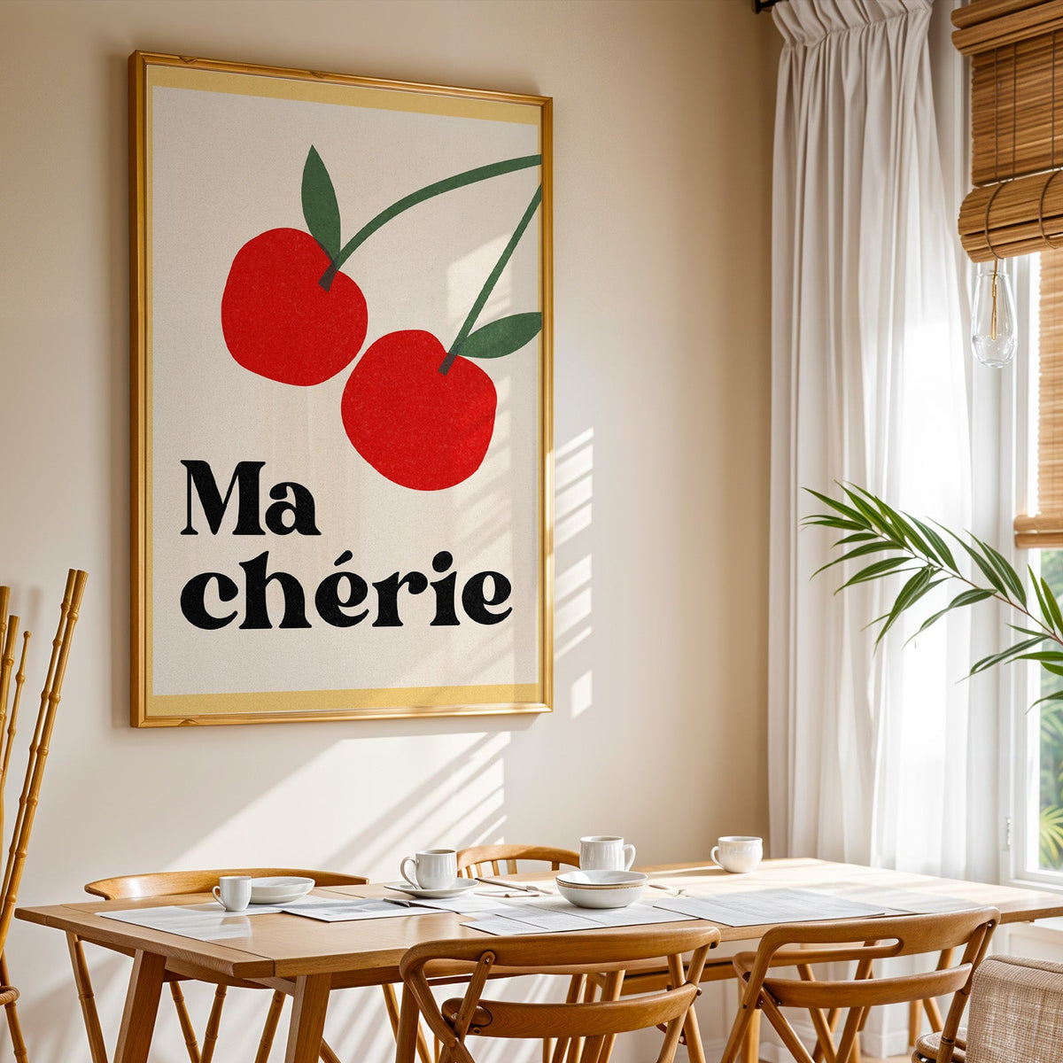 Ma Cherie cherries print shown in a gold frame above a breakfast table by a curtained window