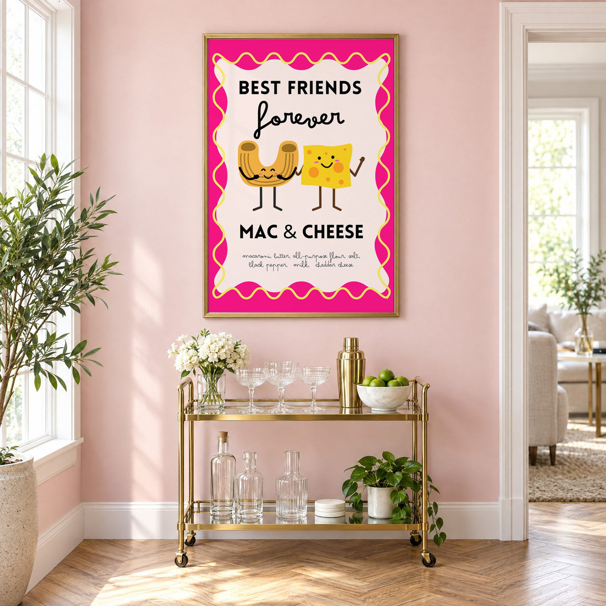 Mac and cheese best friends pink print in a brass frame above a gold bar cart on a blush pink wall