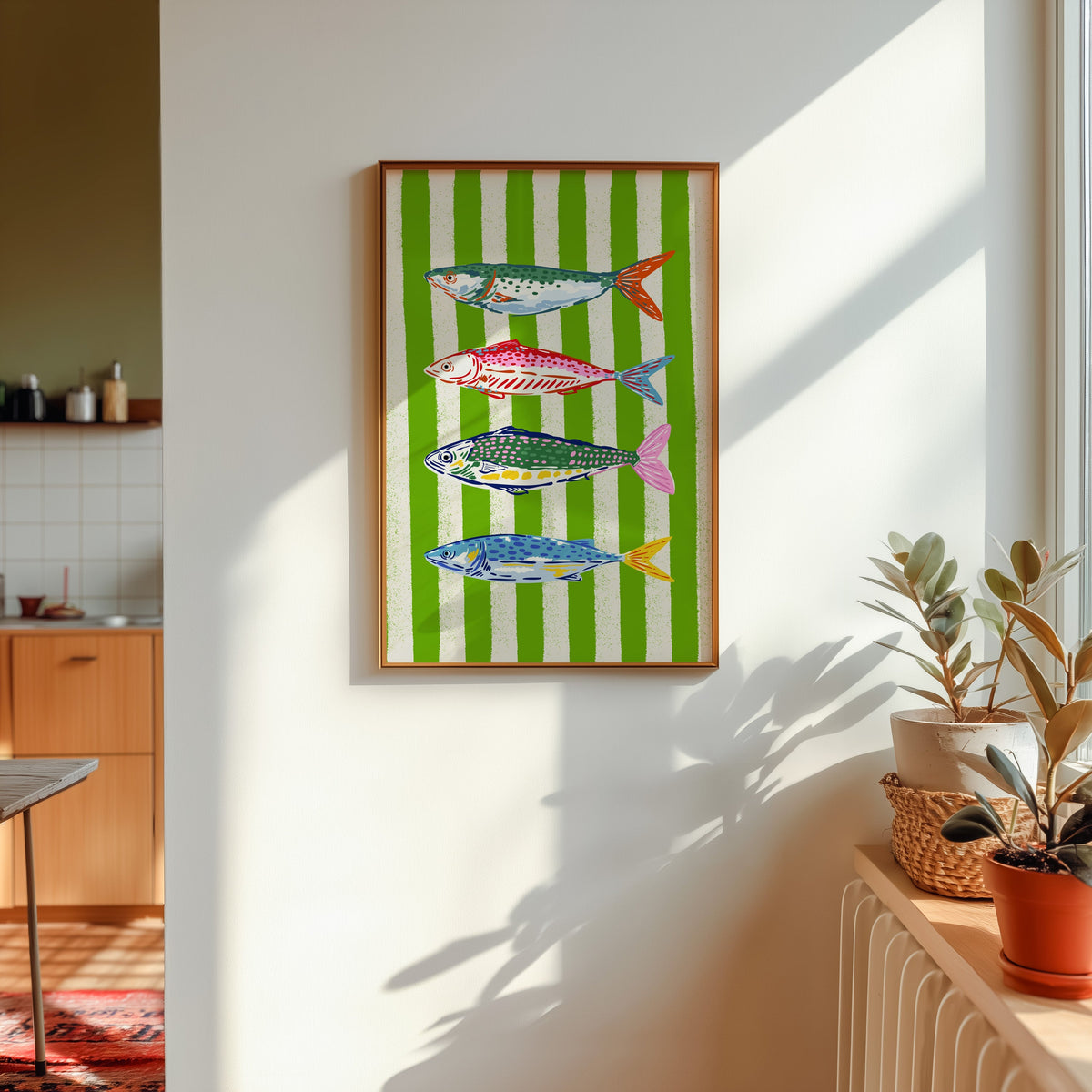 Mackerel row print shown in a gold frame in sunlight with plants and a kitchen beyond