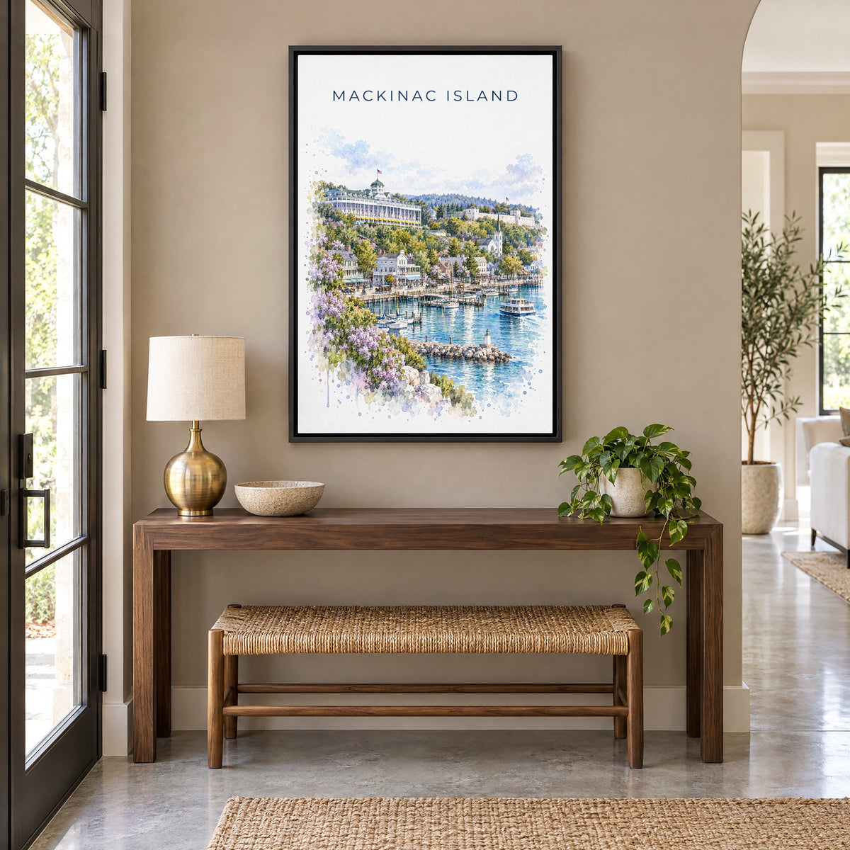 Mackinac Island watercolor print as a black floater canvas above a walnut console and woven bench in an entryway