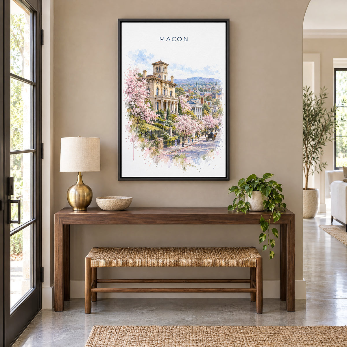 Macon, Georgia watercolor print as a black floater canvas above a walnut console and woven bench in an entryway