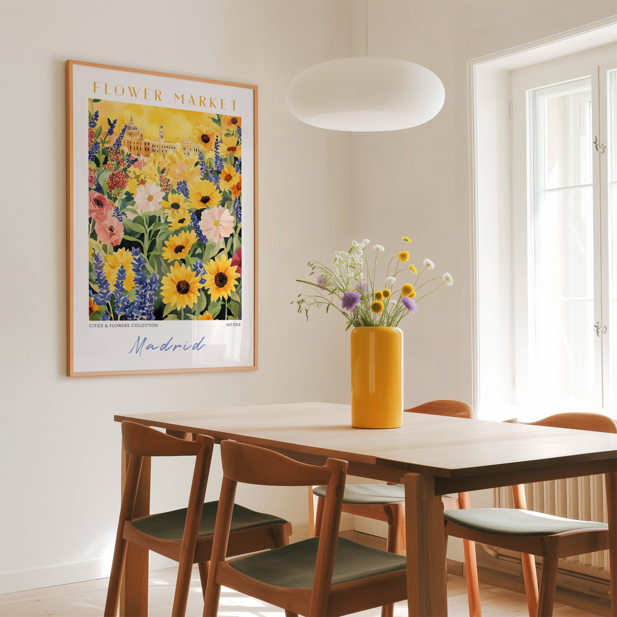 Madrid flower market print in an oak frame above a dining table with a yellow vase and white pendant light
