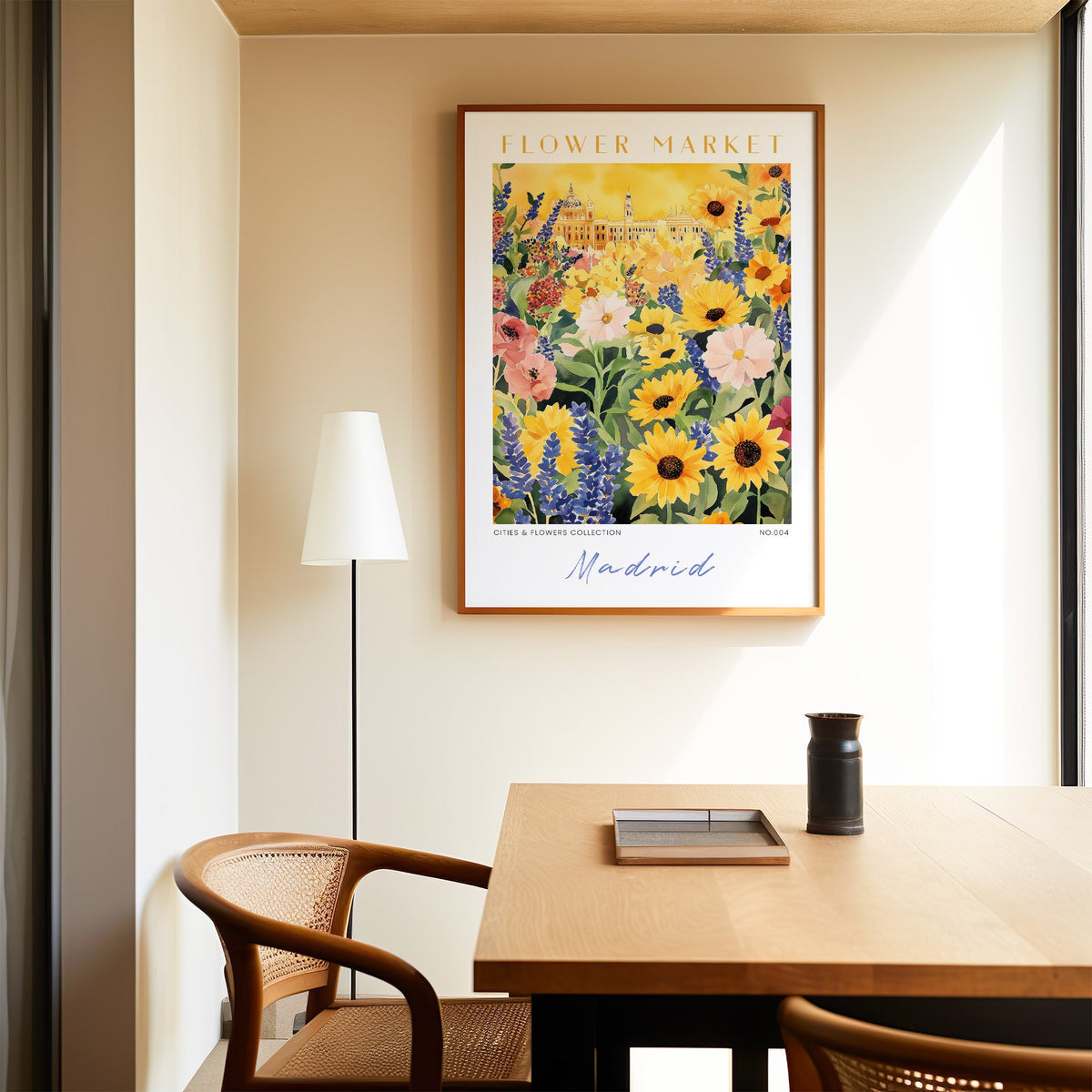 Madrid flower market print in an oak frame above a dining table and cane chair