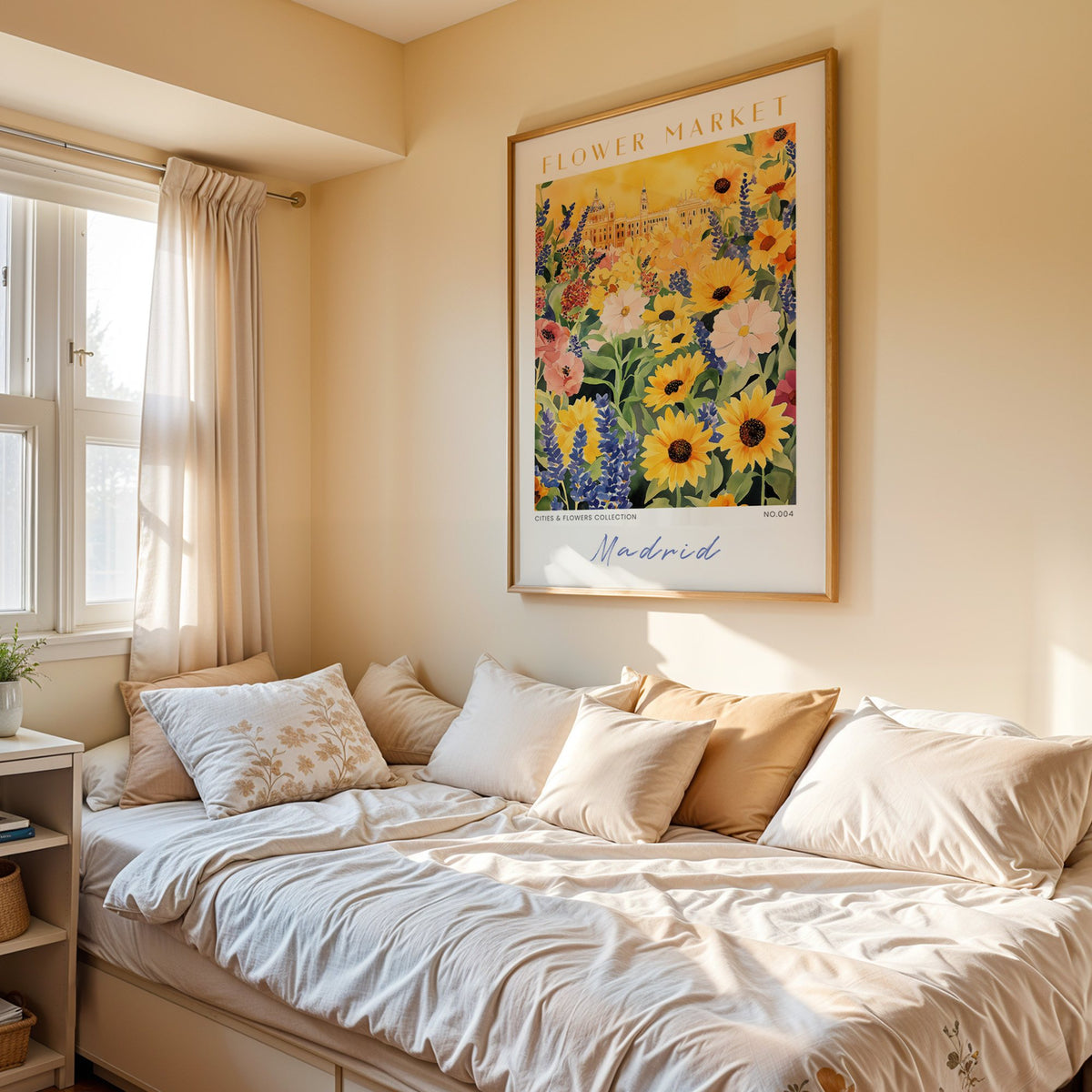 Madrid flower market print in an oak frame above a cream daybed in a sunny bedroom
