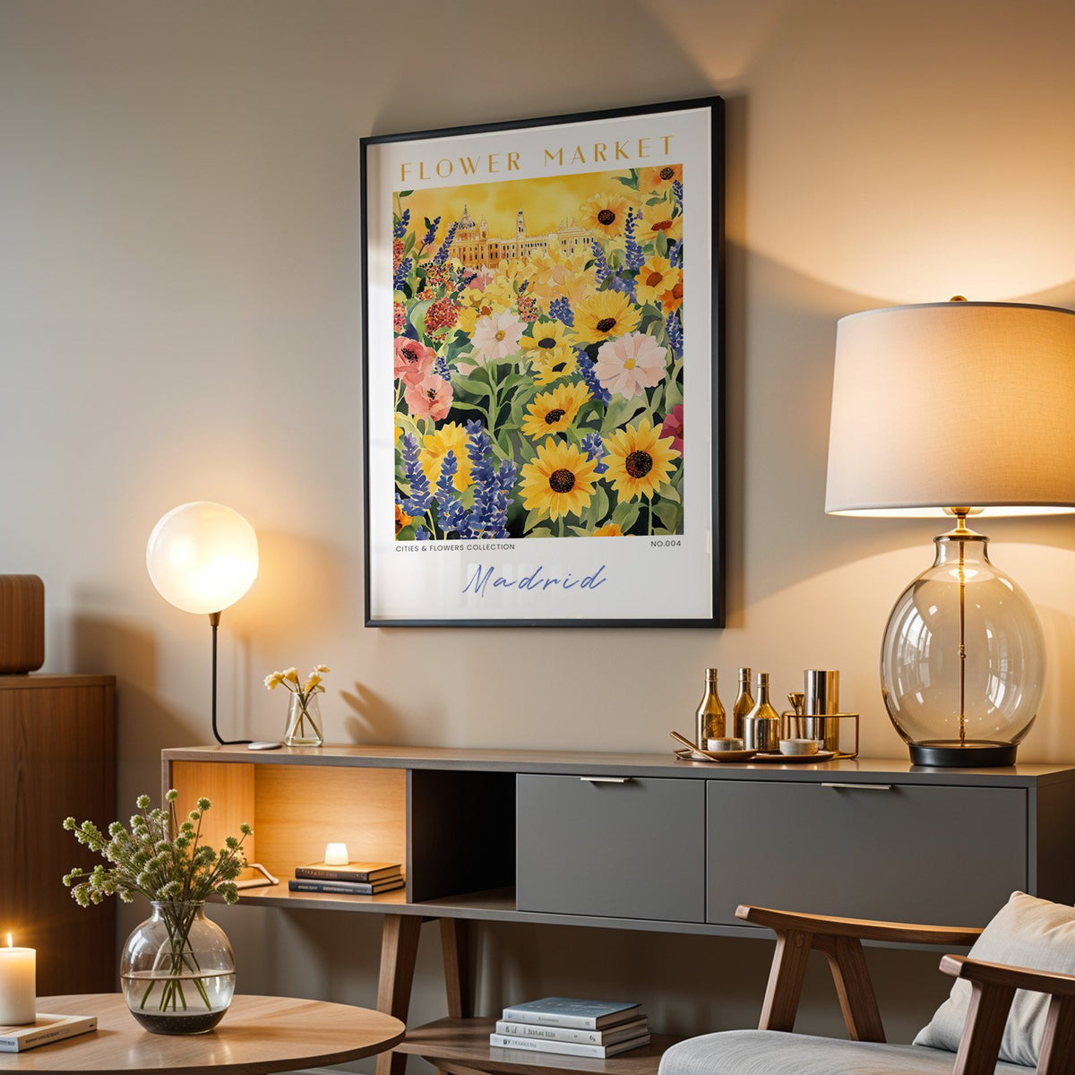 Madrid flower market print in a black frame above a grey media console with a glass table lamp
